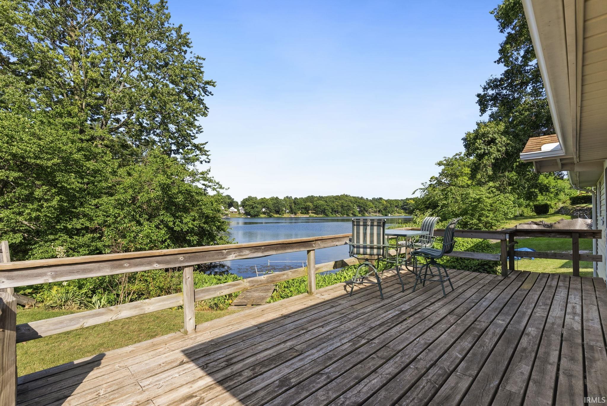 Expansive wood deck with a natural wood railing overlooking a body of water