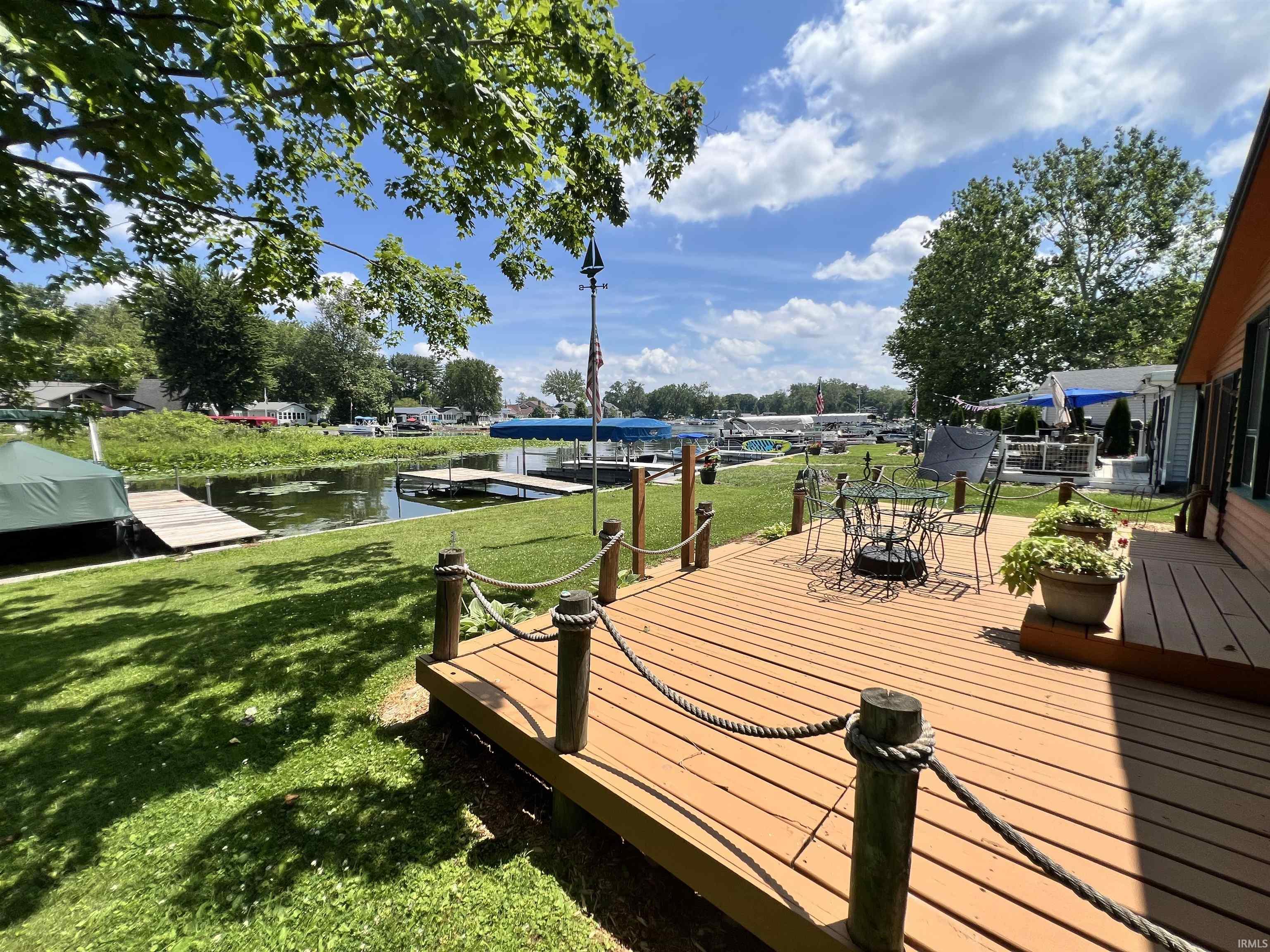 Expansive waterside deck with a rope railing and wood-finish surface