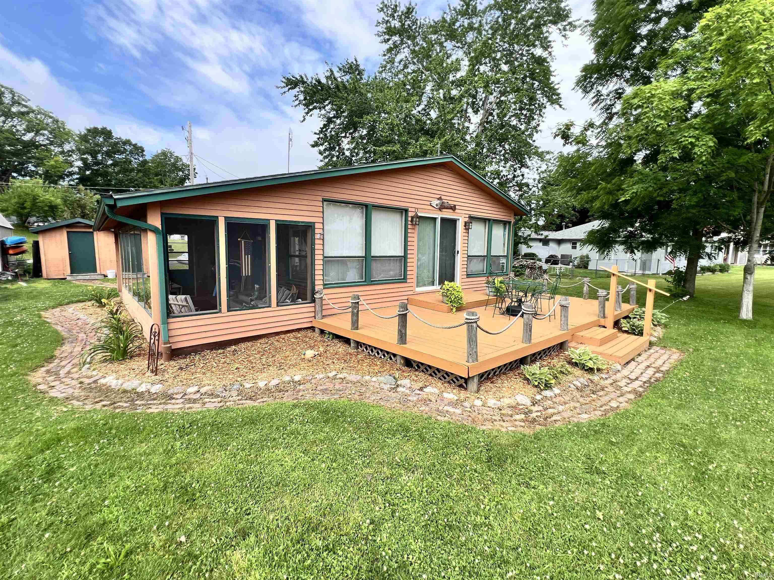 Exterior showcasing a screened porch, a wood-finish deck with rope railing, and a sliding glass door entry
