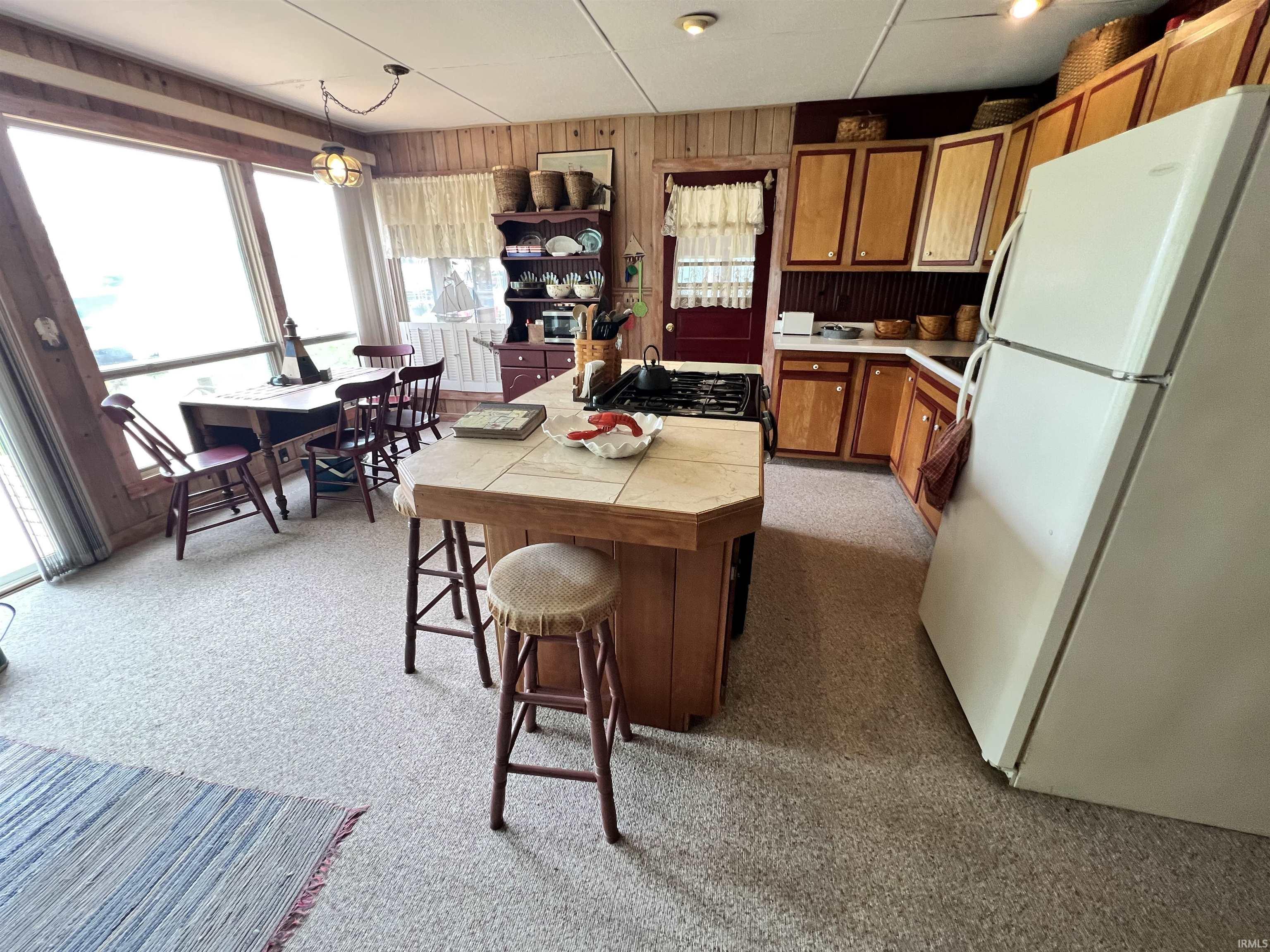 Kitchen area featuring wood plank paneling and light-toned flooring