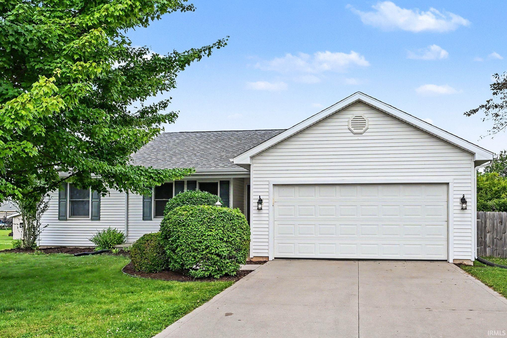 Single-story residence featuring white siding, an attached two-car garage with an automatic door, and a concrete driveway
