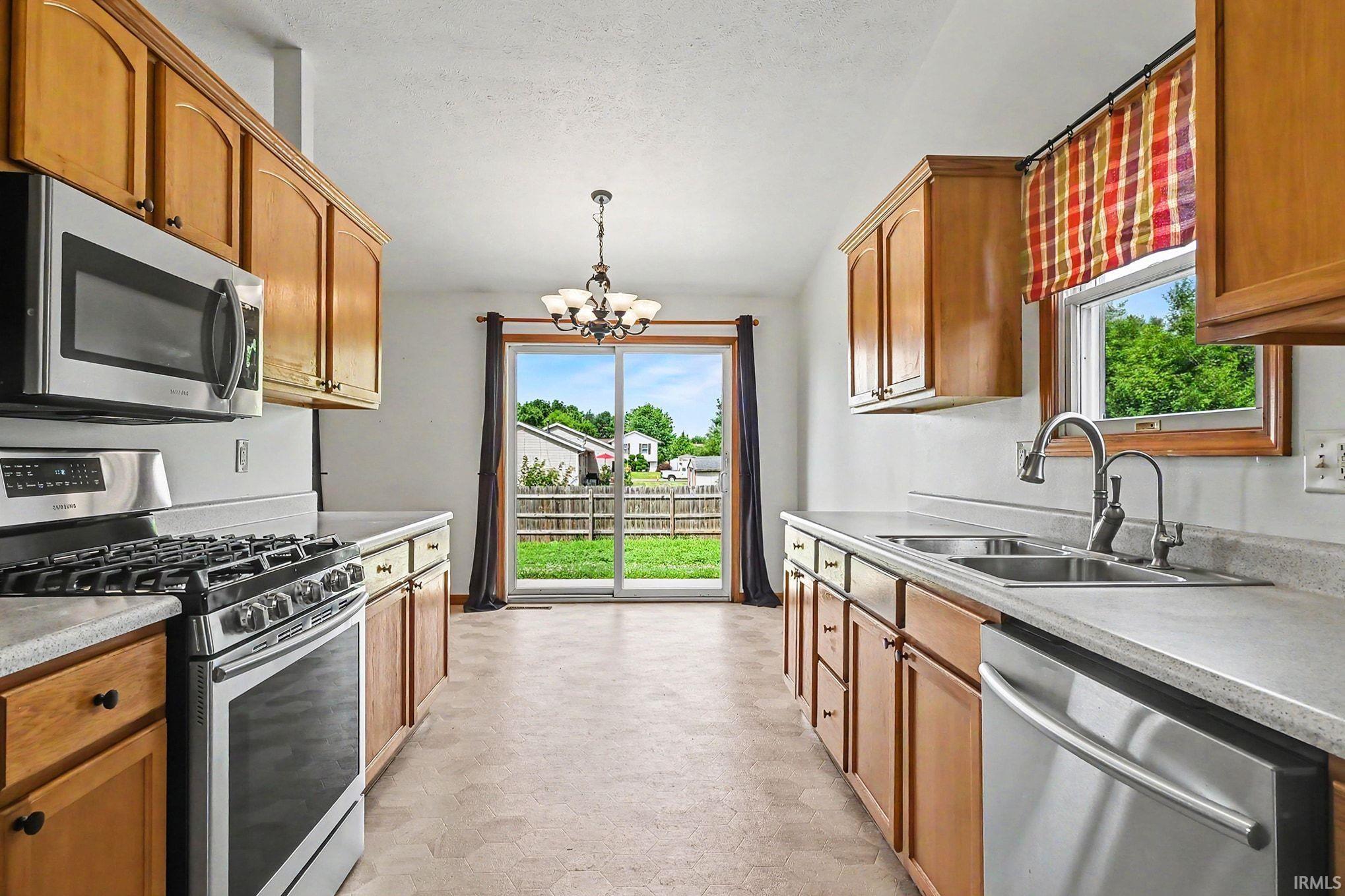Kitchen with stainless steel appliances including a range, microwave, and dishwasher, and a double basin sink