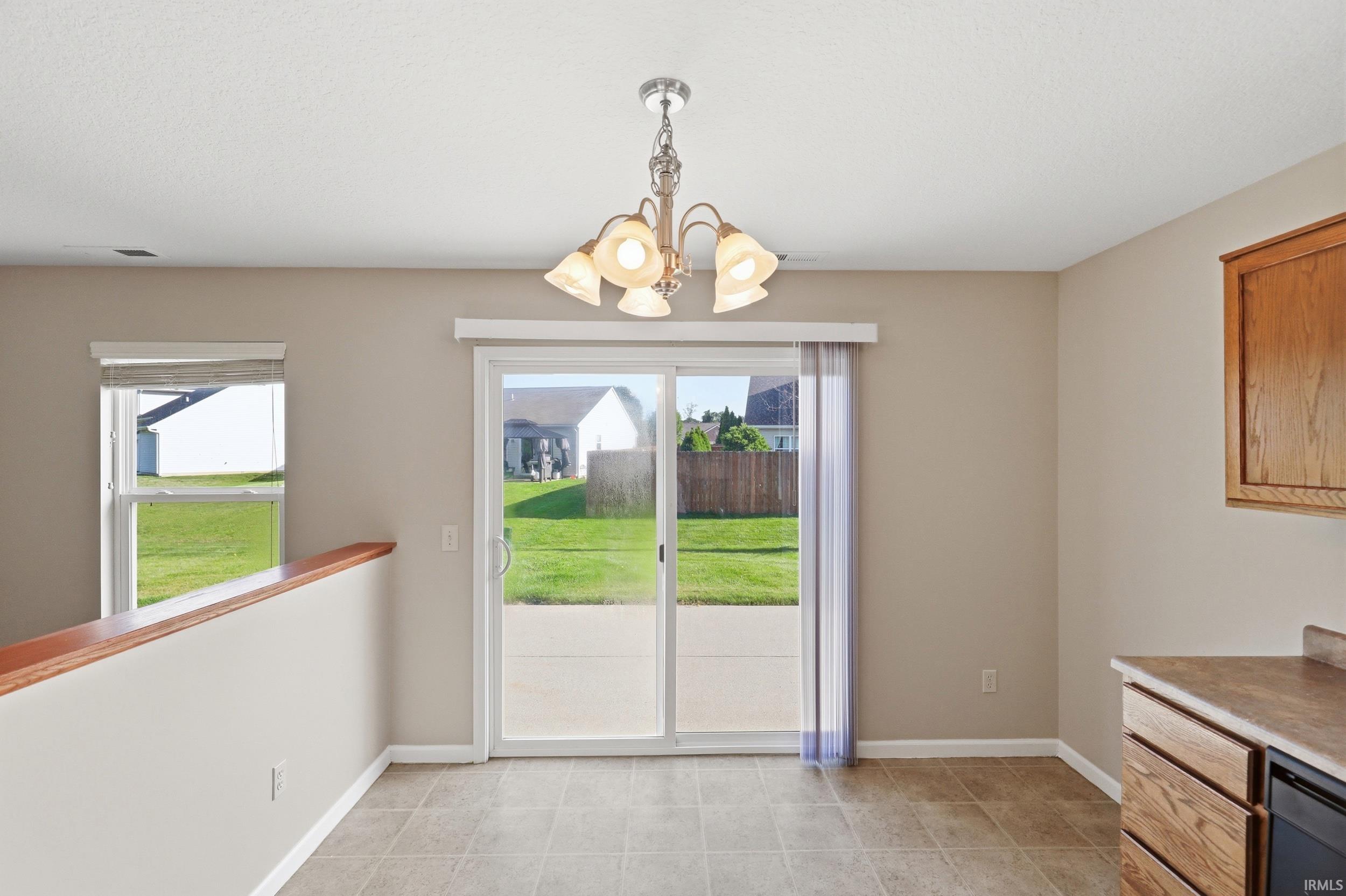 Dining area featuring a chandelier, ceramic tile flooring, and sliding glass doors to the outdoor patio