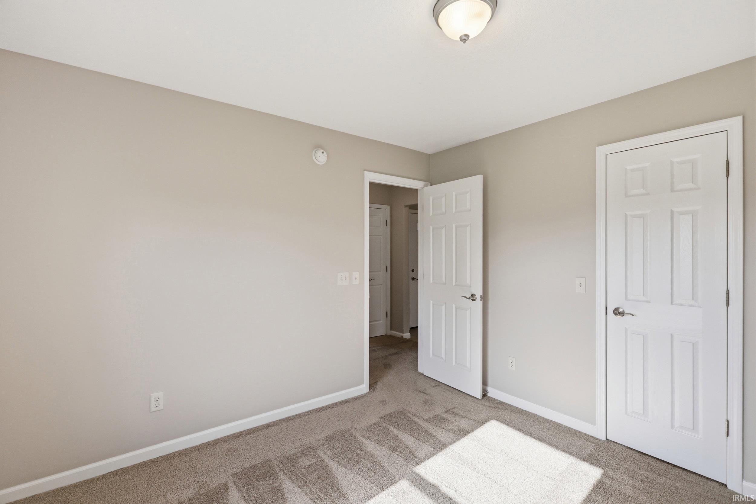 Neutral-toned walls complement plush carpet flooring
