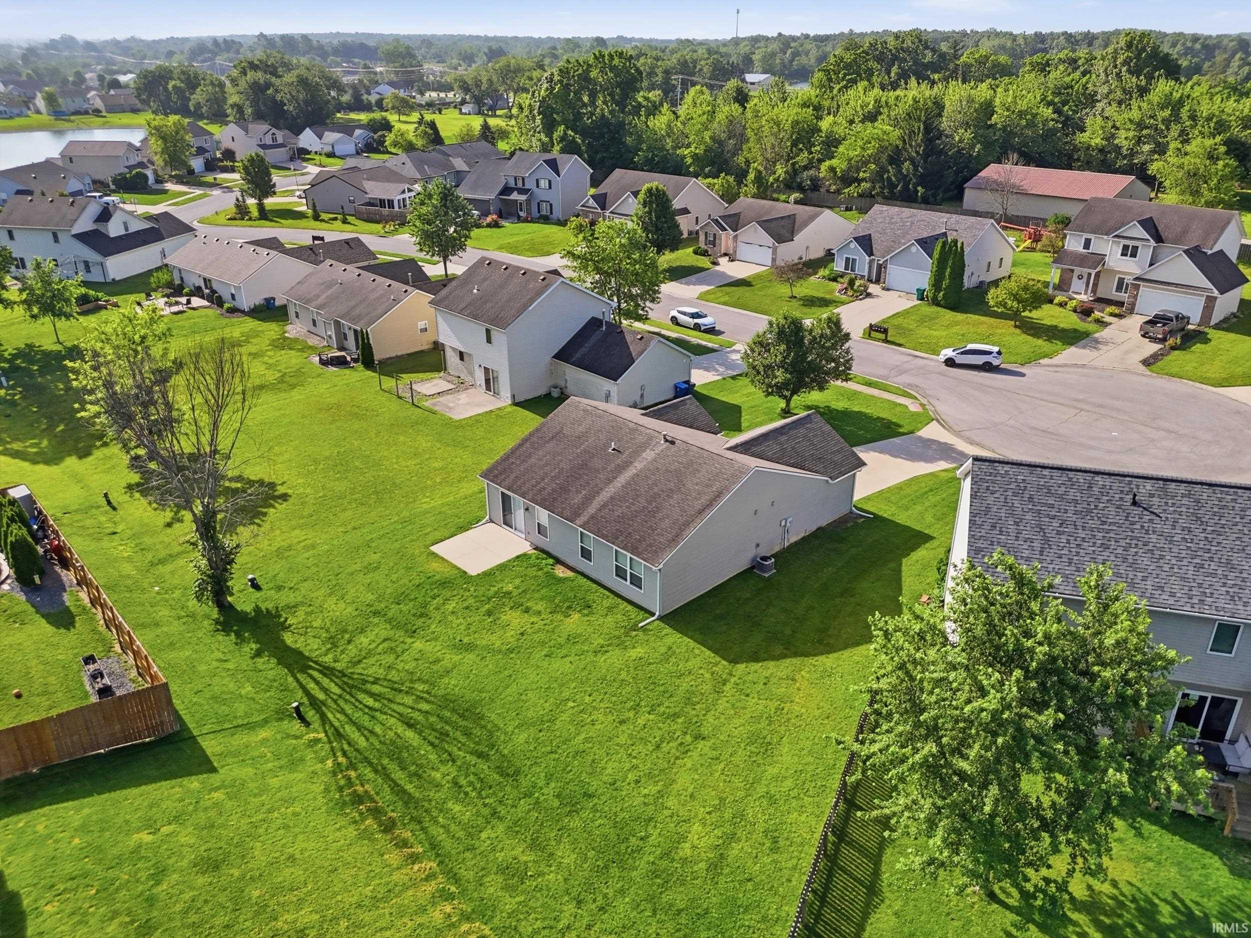 Expansive residential neighborhood featuring single-story and two-story homes, broad green lawns, and mature trees