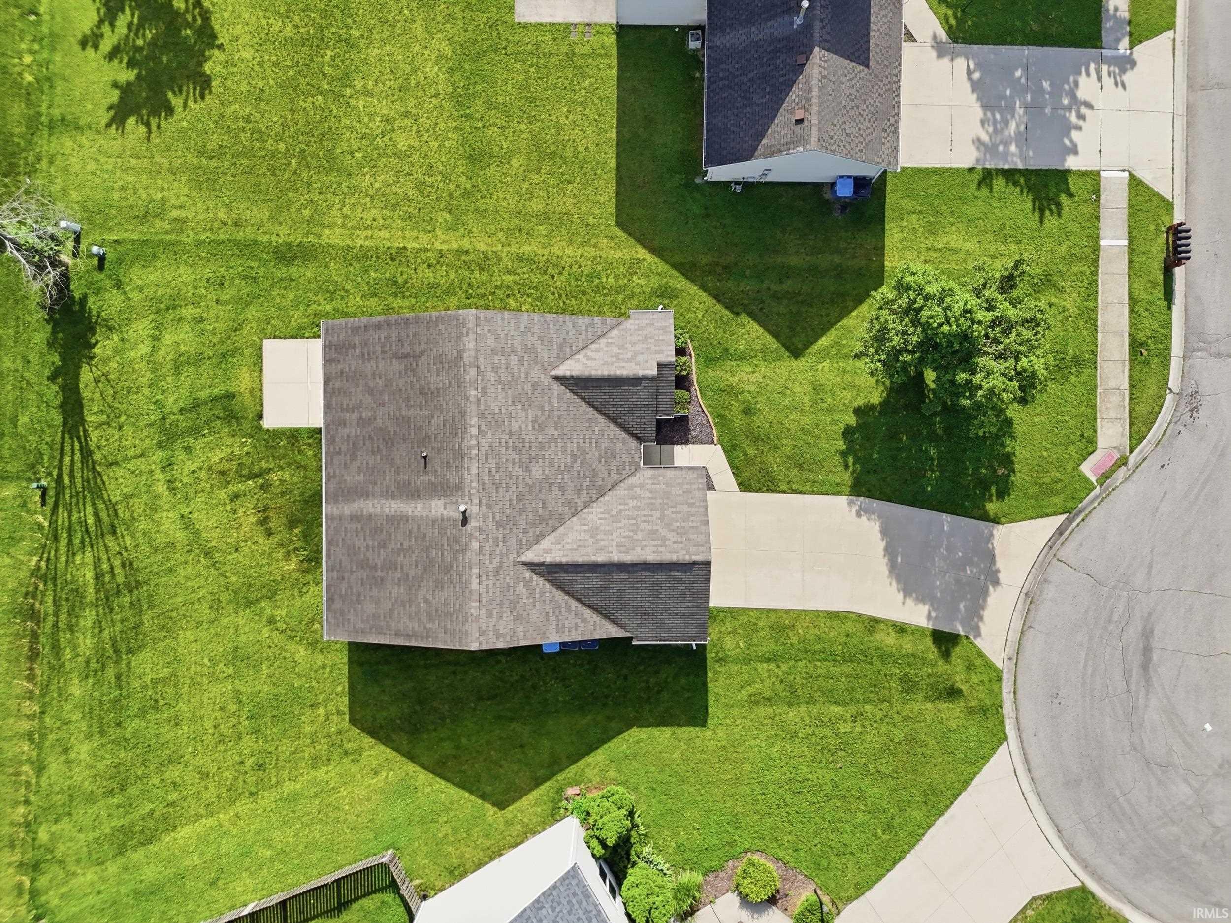 Expansive property featuring a multi-gabled roofline, concrete driveway, and a large green lawn