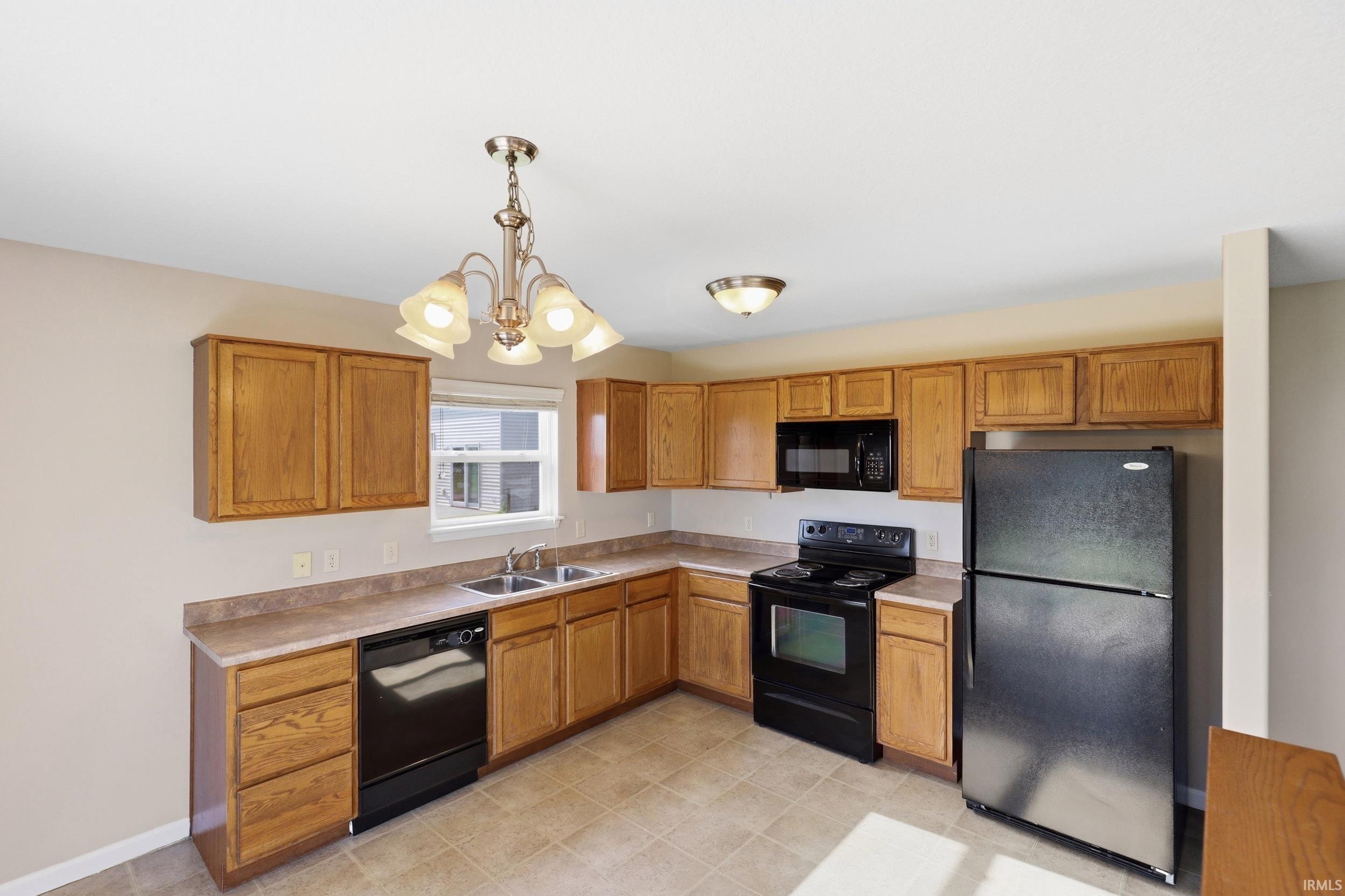 Kitchen featuring light wood cabinetry, light countertops, and tile flooring