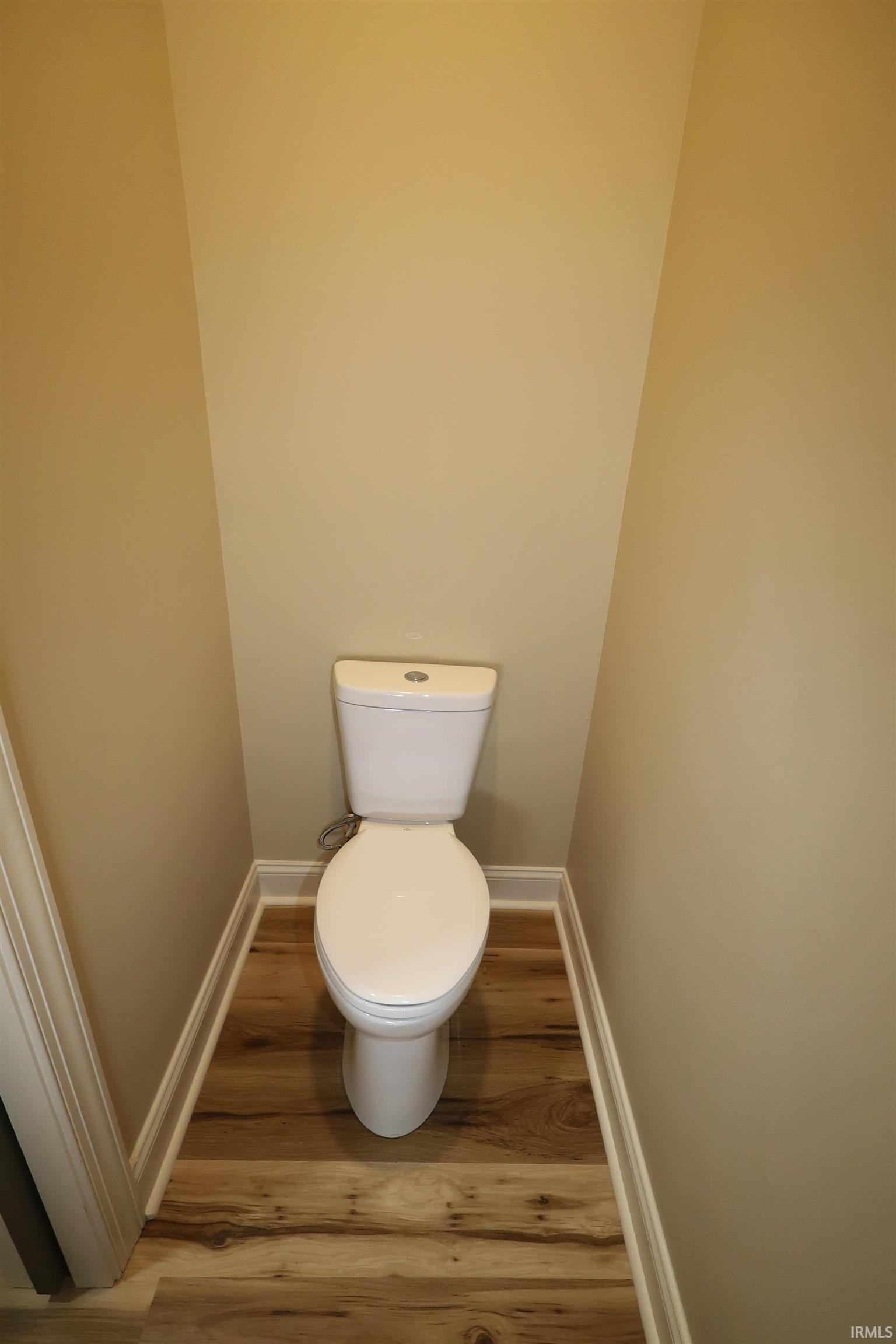 White two-piece toilet set against neutral-toned walls