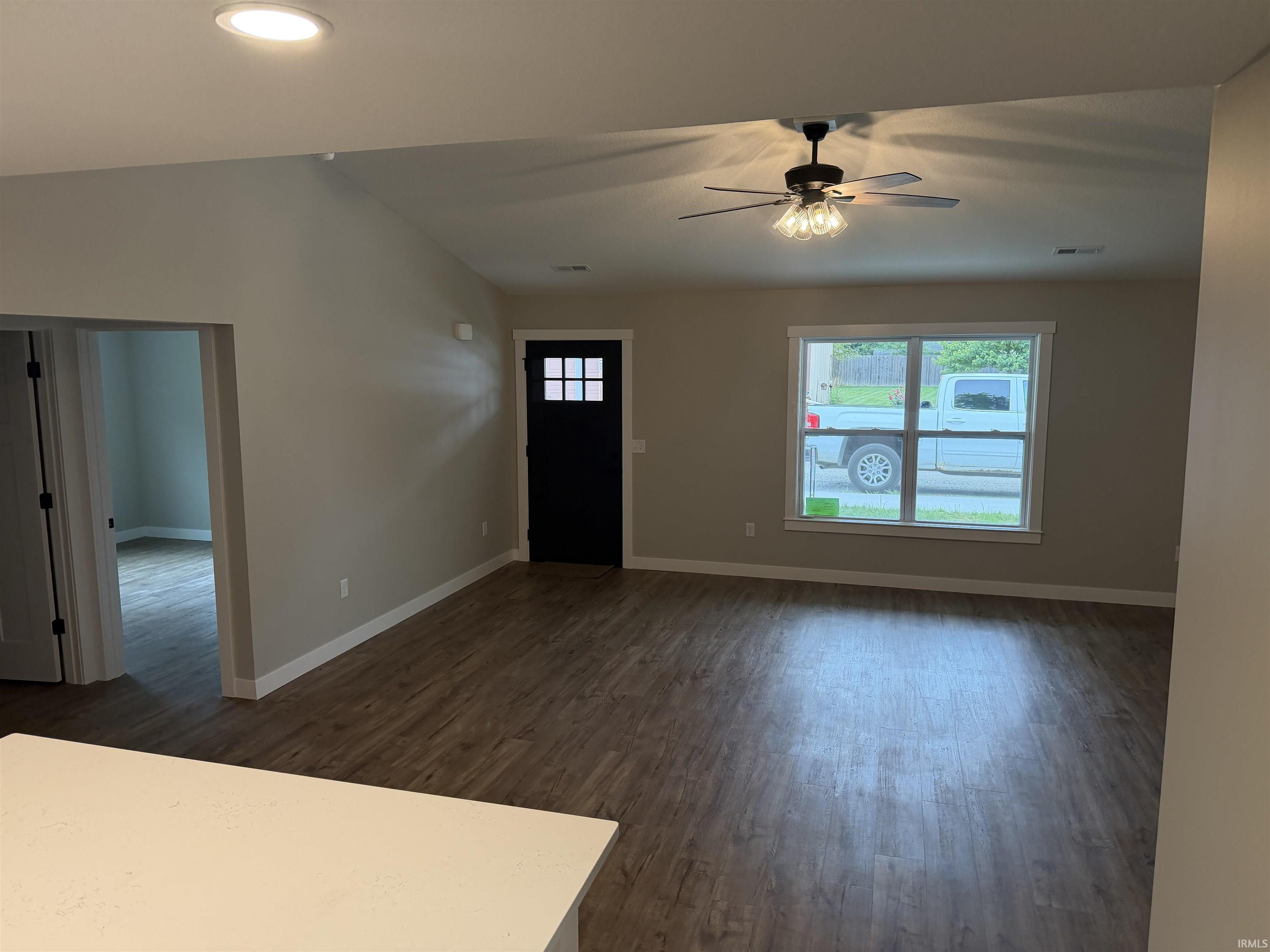 Spacious living area featuring wood-finish flooring, recessed lighting, and a ceiling fan