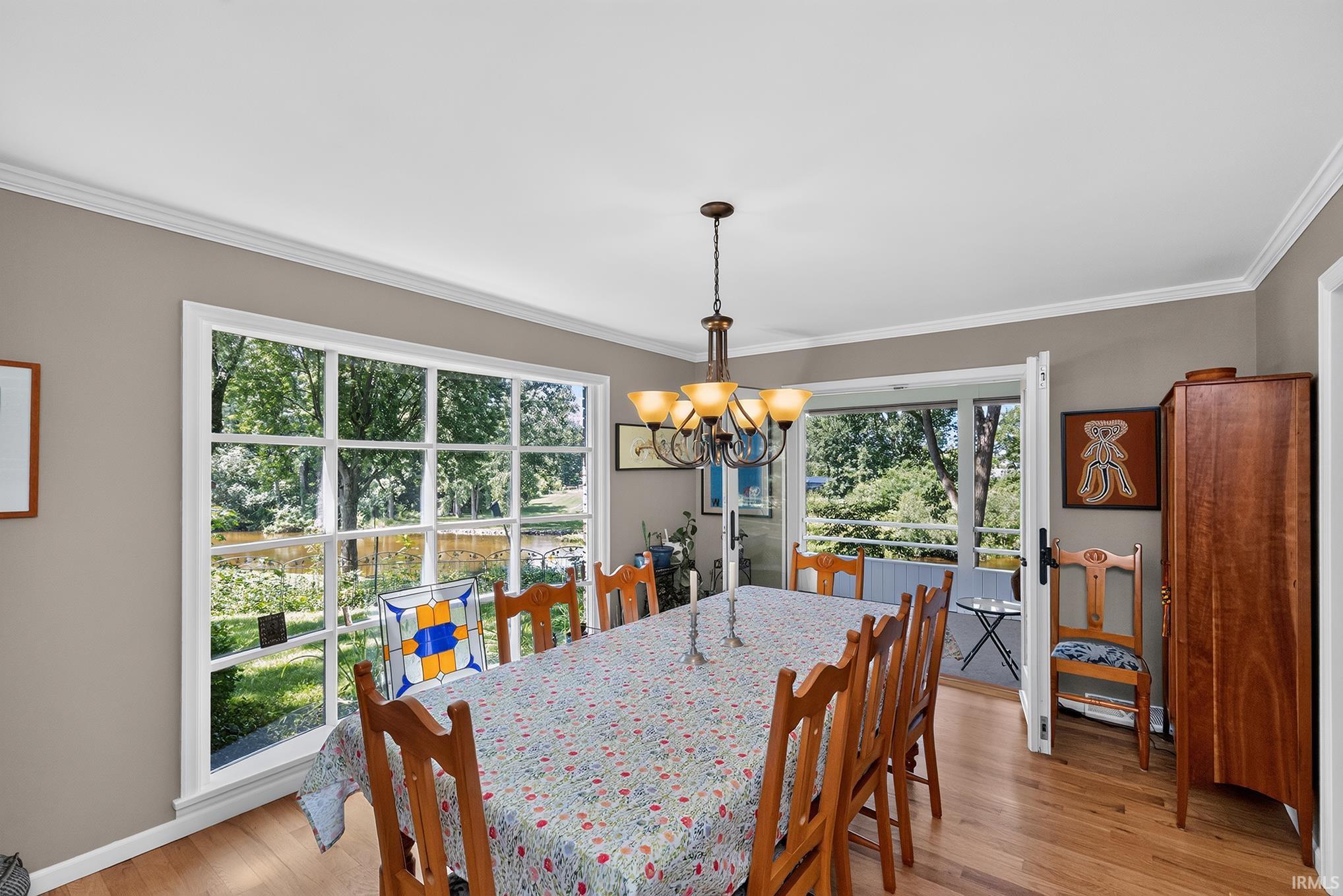 Dining area featuring wood-finish flooring and crown molding