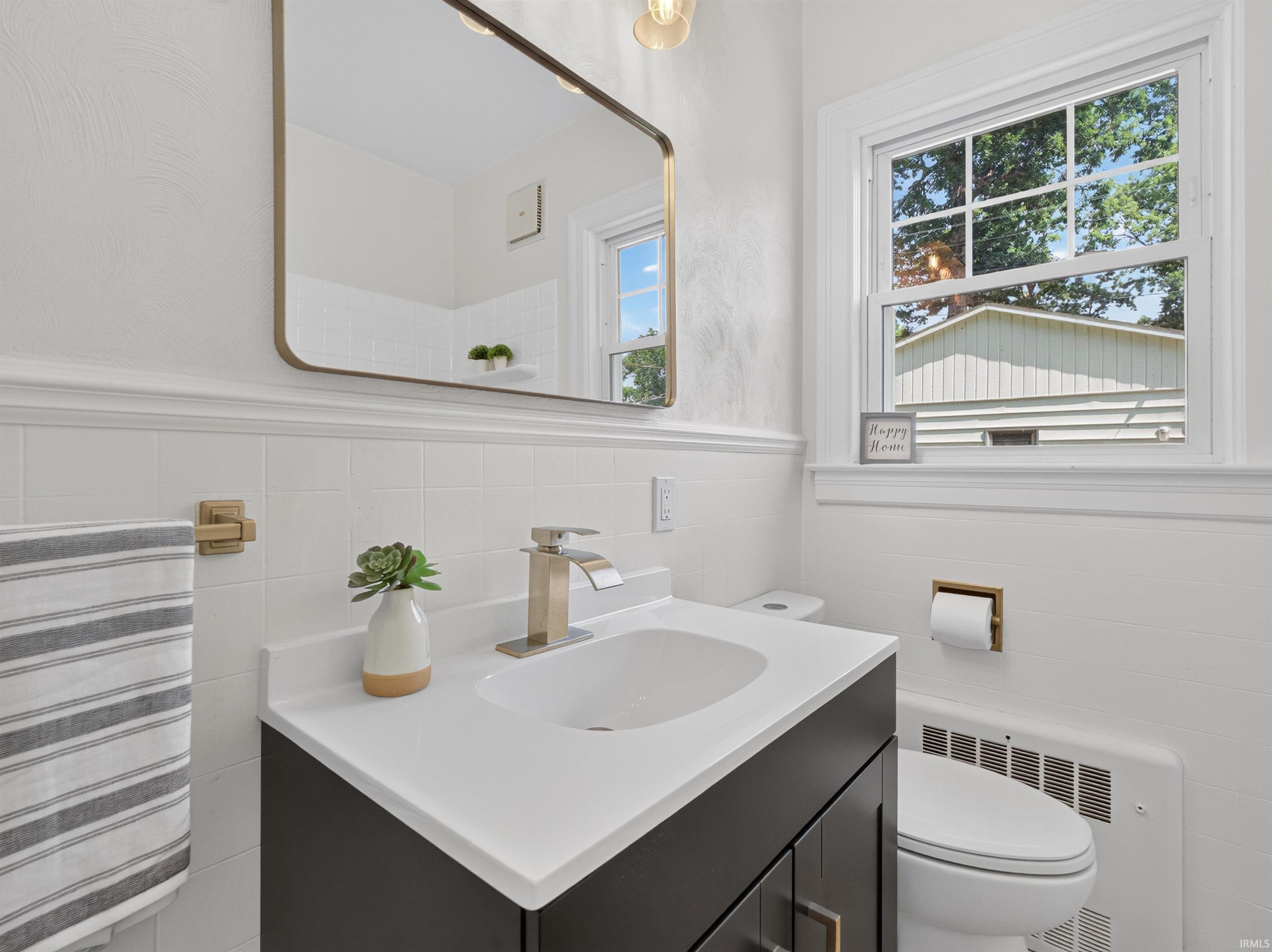 Modern vanity with integrated sink, brushed nickel waterfall faucet, and white quartz countertop