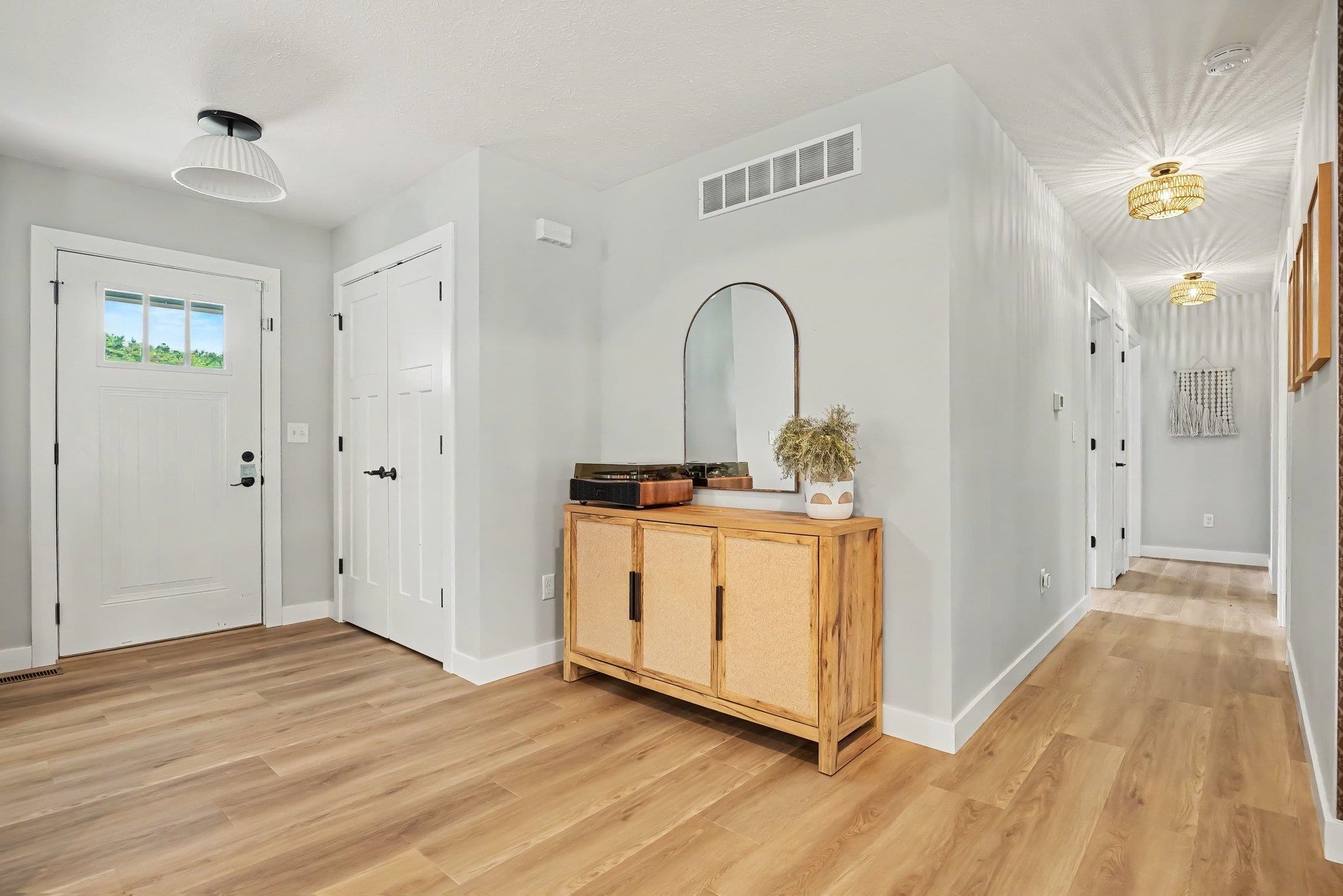 Entryway featuring wood-finish flooring, a white paneled entry door with a multi-pane window, and a recessed ceiling light fixture