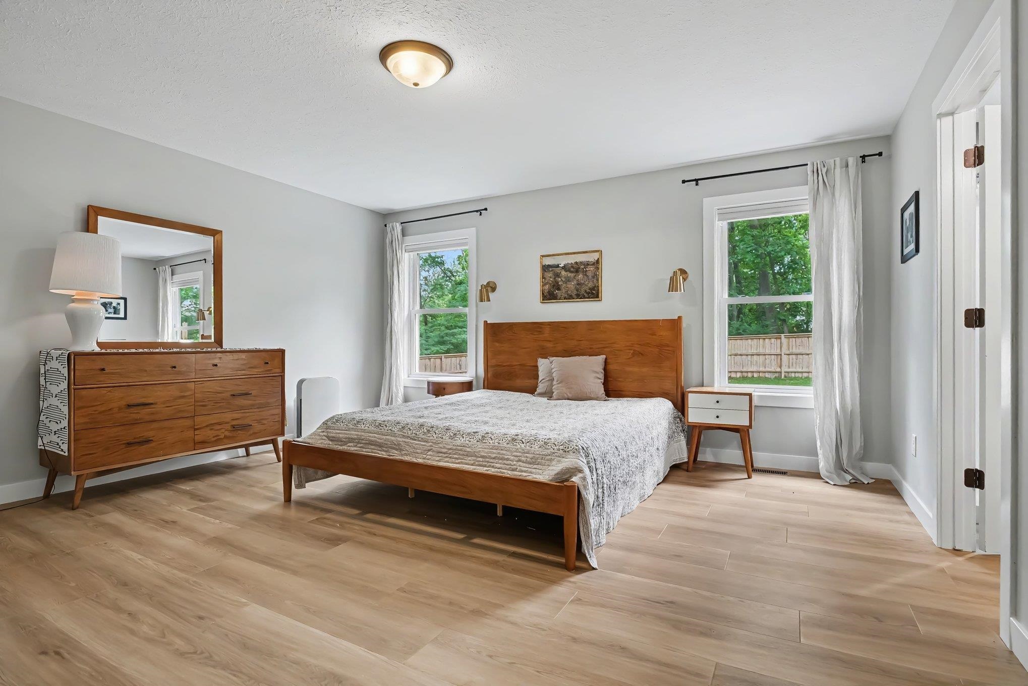 Spacious room featuring light wood-finish flooring and light grey wall tones