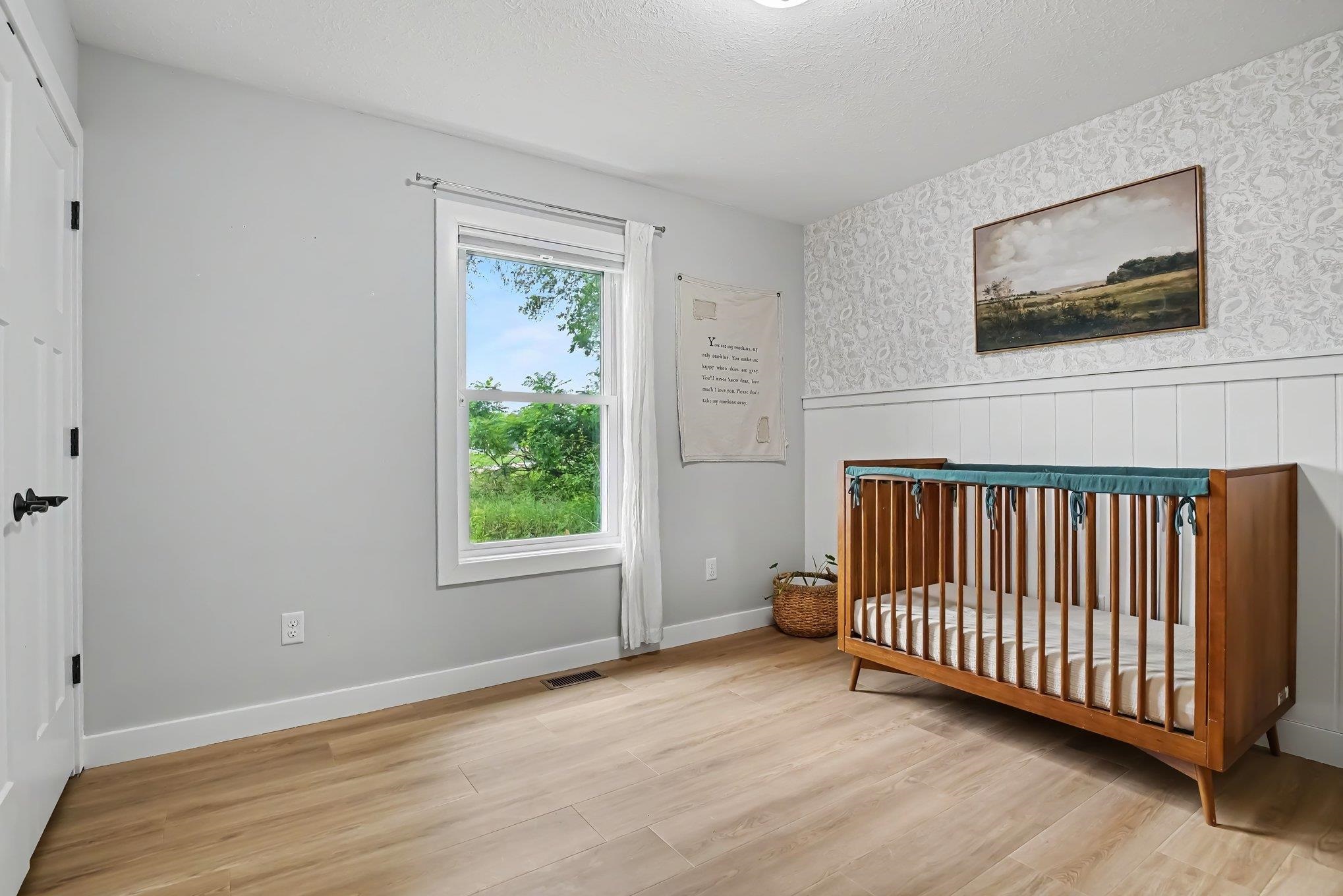 Light-toned wood-finish flooring complements the neutral wall color