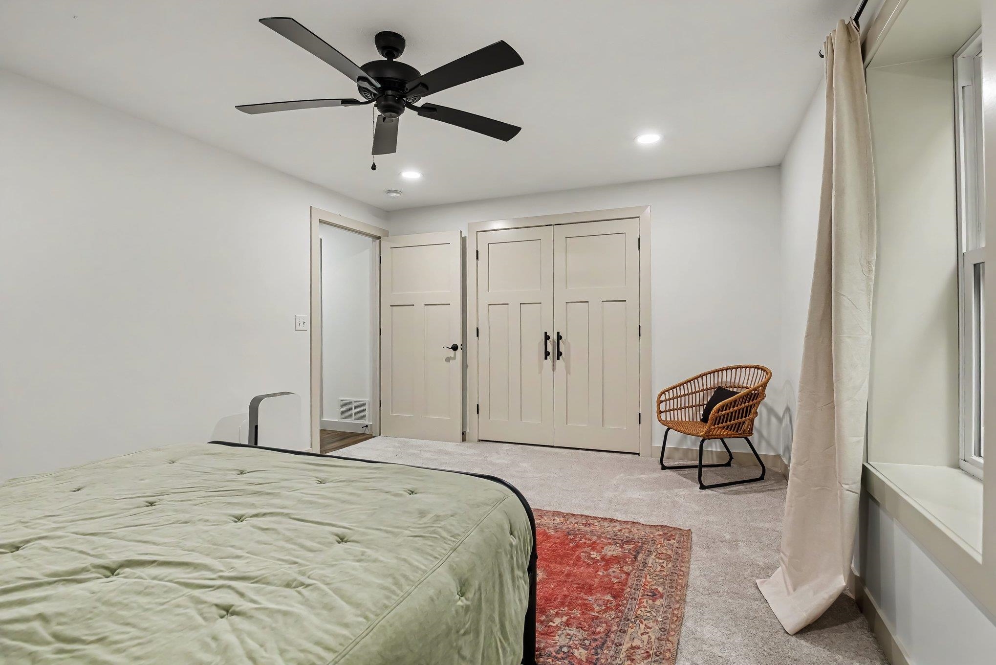 Neutral toned room featuring a dark-bladed ceiling fan, recessed lighting, and soft carpet flooring