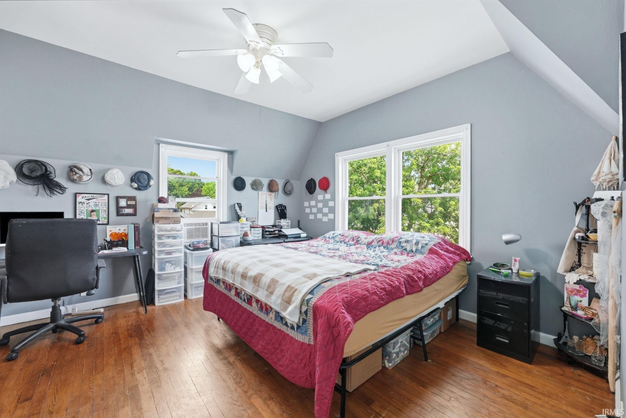 Room featuring wood-finish flooring, two large windows