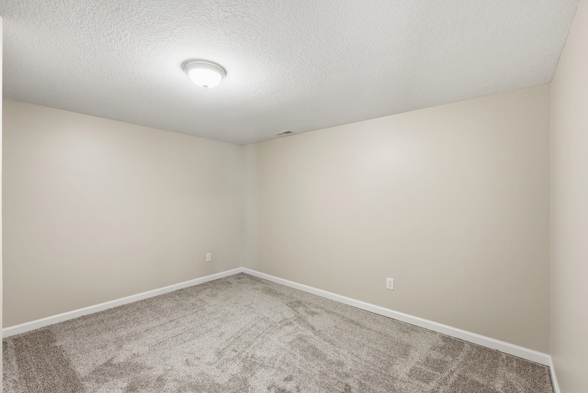 Neutral-toned walls complement the gray carpet flooring