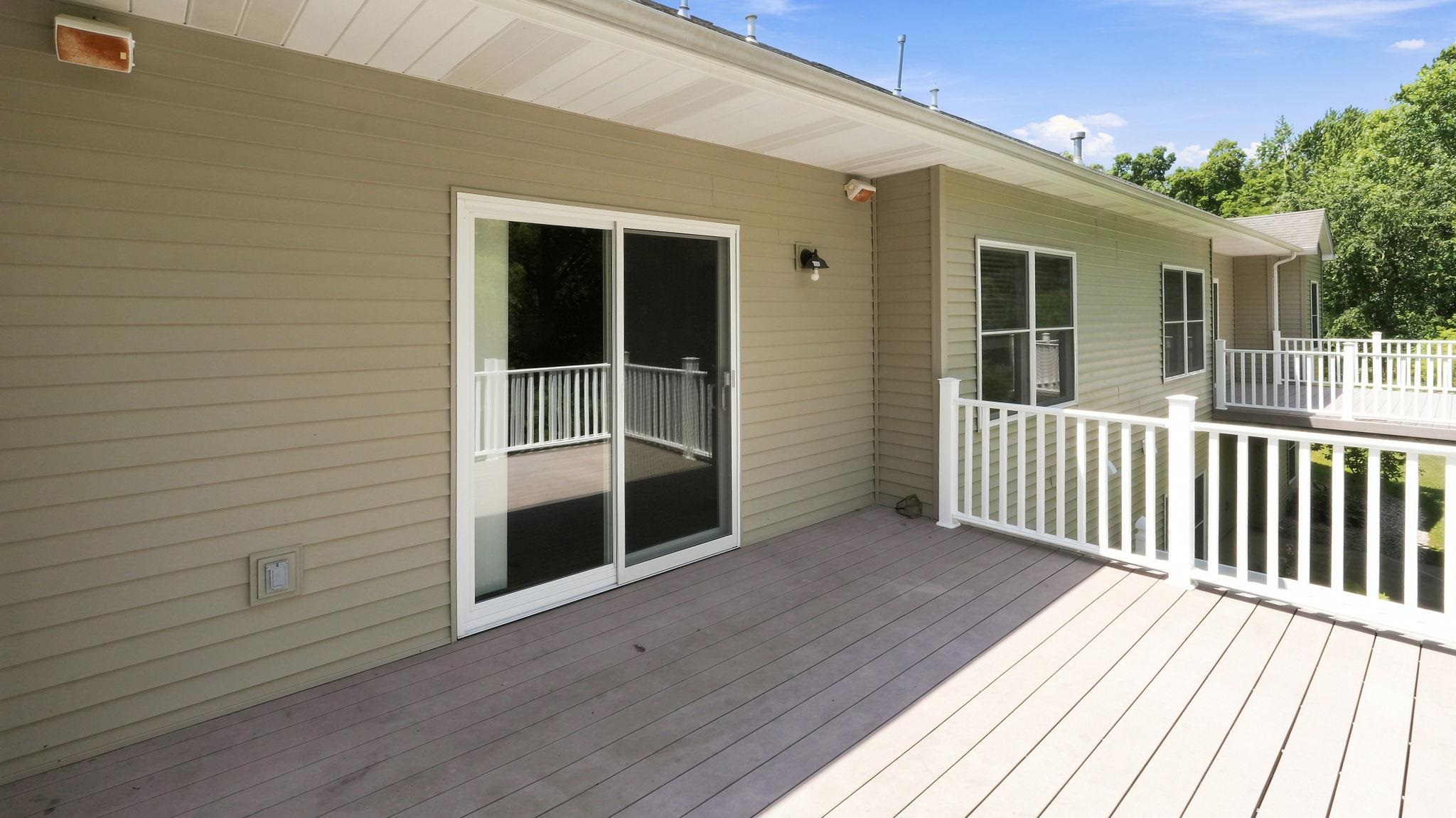 Spacious outdoor deck featuring composite decking and white railings