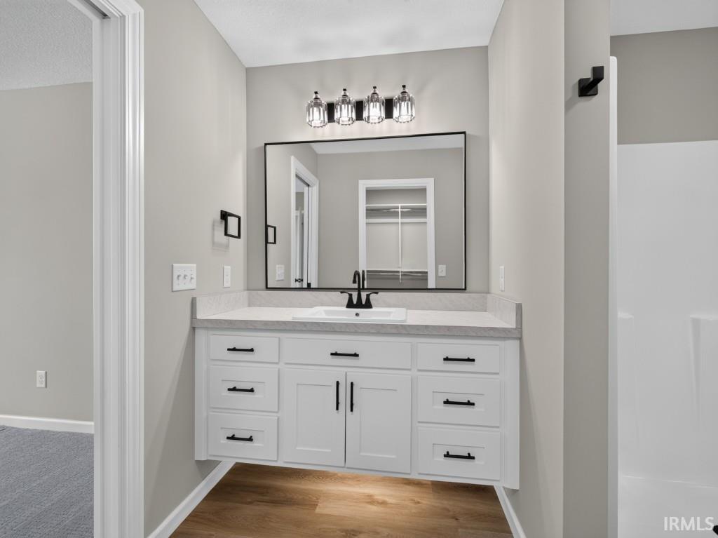 White floating vanity with black hardware, integrated sink, and light-toned countertop