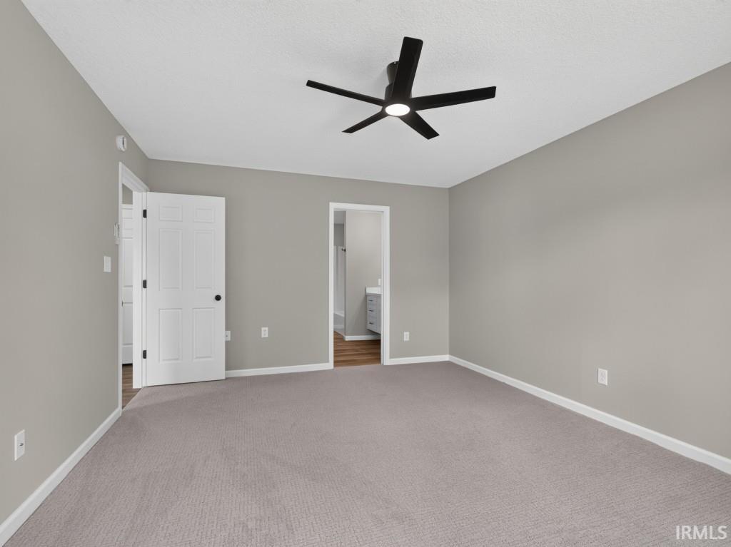 Spacious room featuring neutral carpeting and light gray wall paint