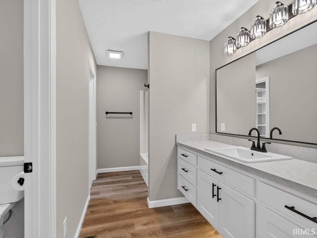 Bathroom featuring a white vanity with black hardware, a rectangular sink, and a light-colored countertop