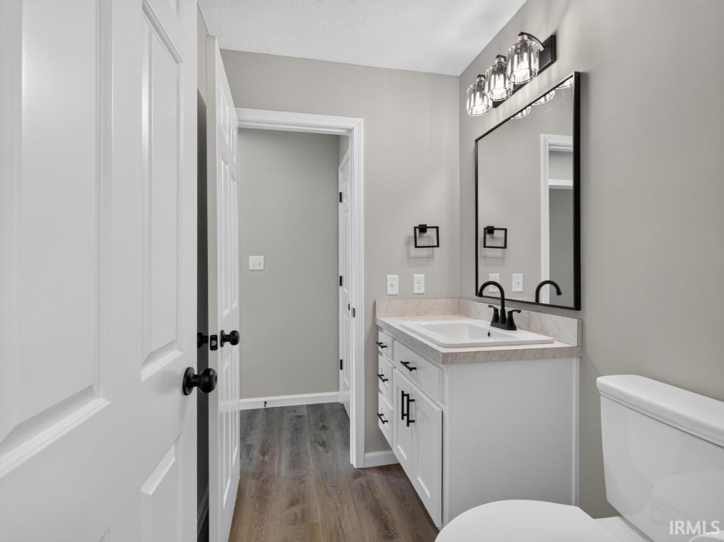 Bathroom featuring a white vanity with a light-toned countertop, black framed mirror, and matte black fixtures