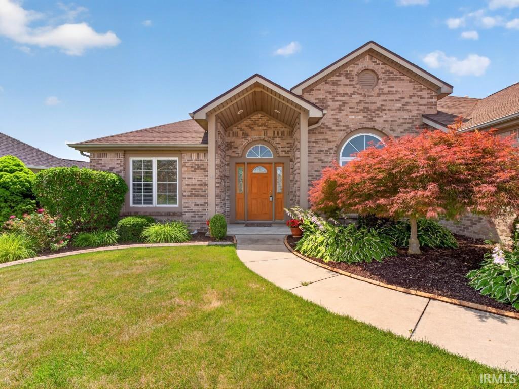 Brick facade residence featuring a welcoming portico entrance, arched transom window, and a prominent arched window
