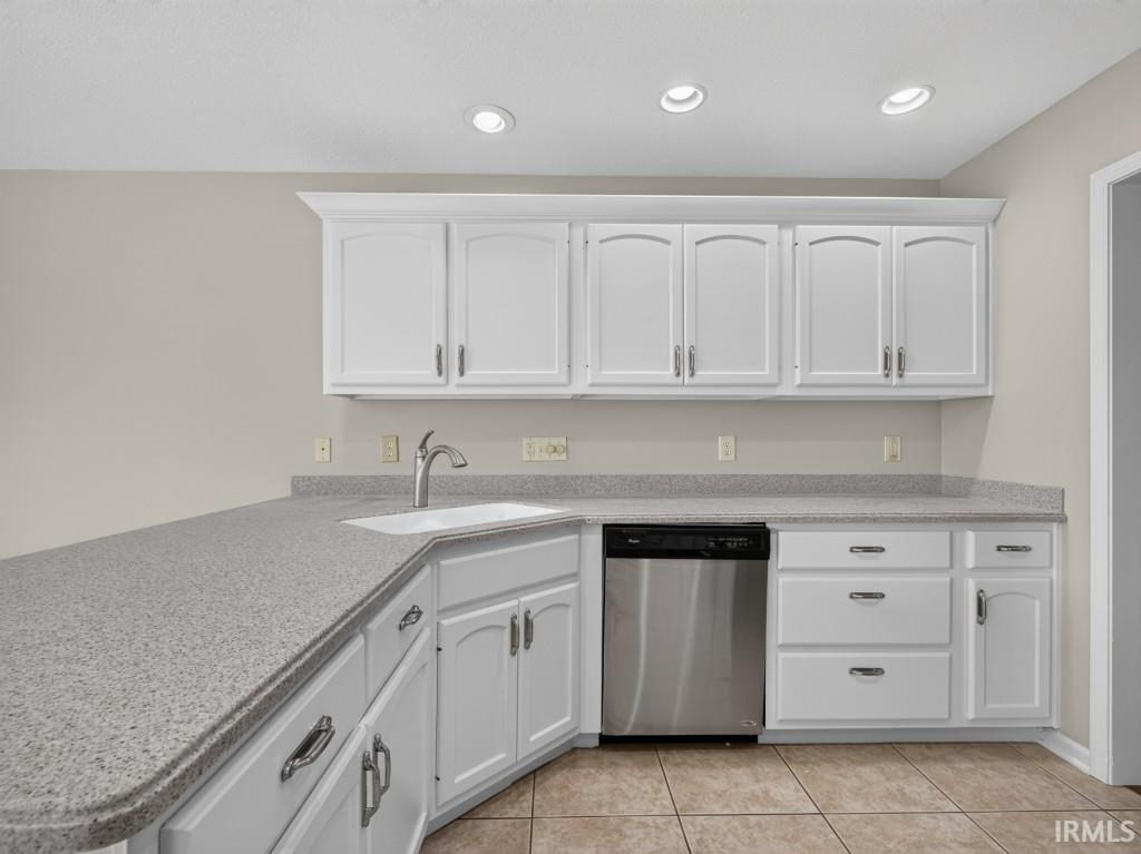 Kitchen featuring white cabinetry with brushed nickel hardware, speckled gray countertops, a stainless steel dishwasher, a single basin sink with a gooseneck faucet, and recessed ceiling lighting