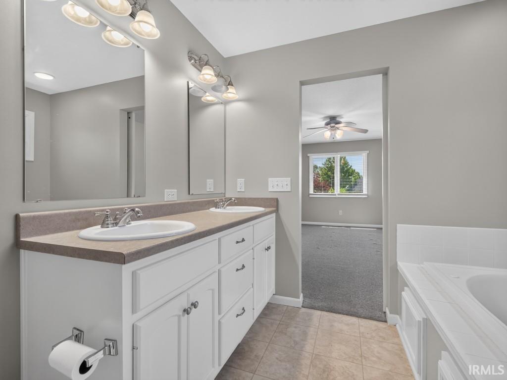 Spacious bathroom featuring a double vanity with white cabinetry and a neutral countertop