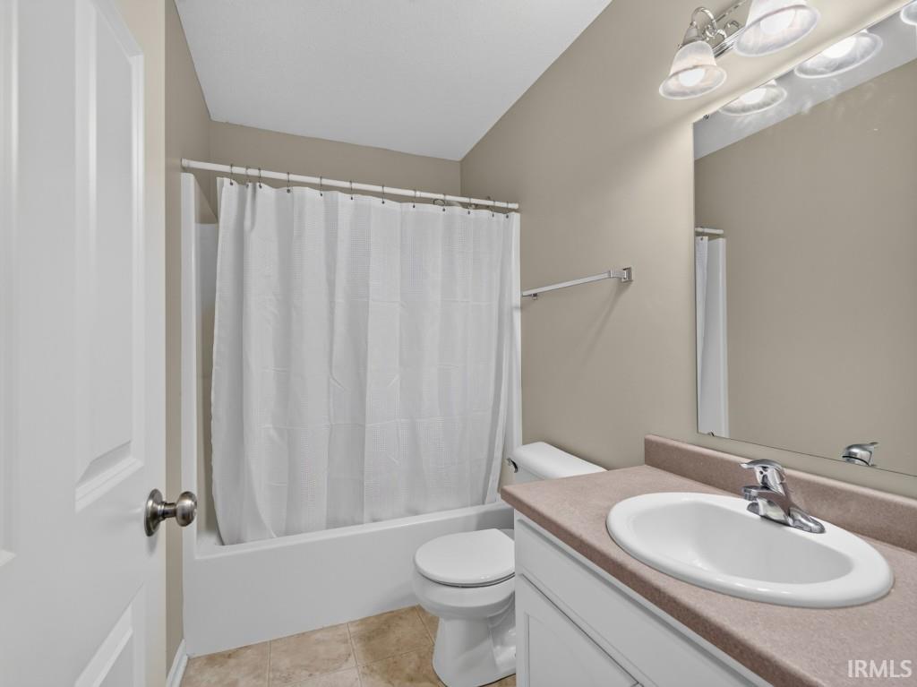 Full bathroom featuring a white vanity with an integrated sink, a light-toned countertop, and a vanity mirror with overhead lighting