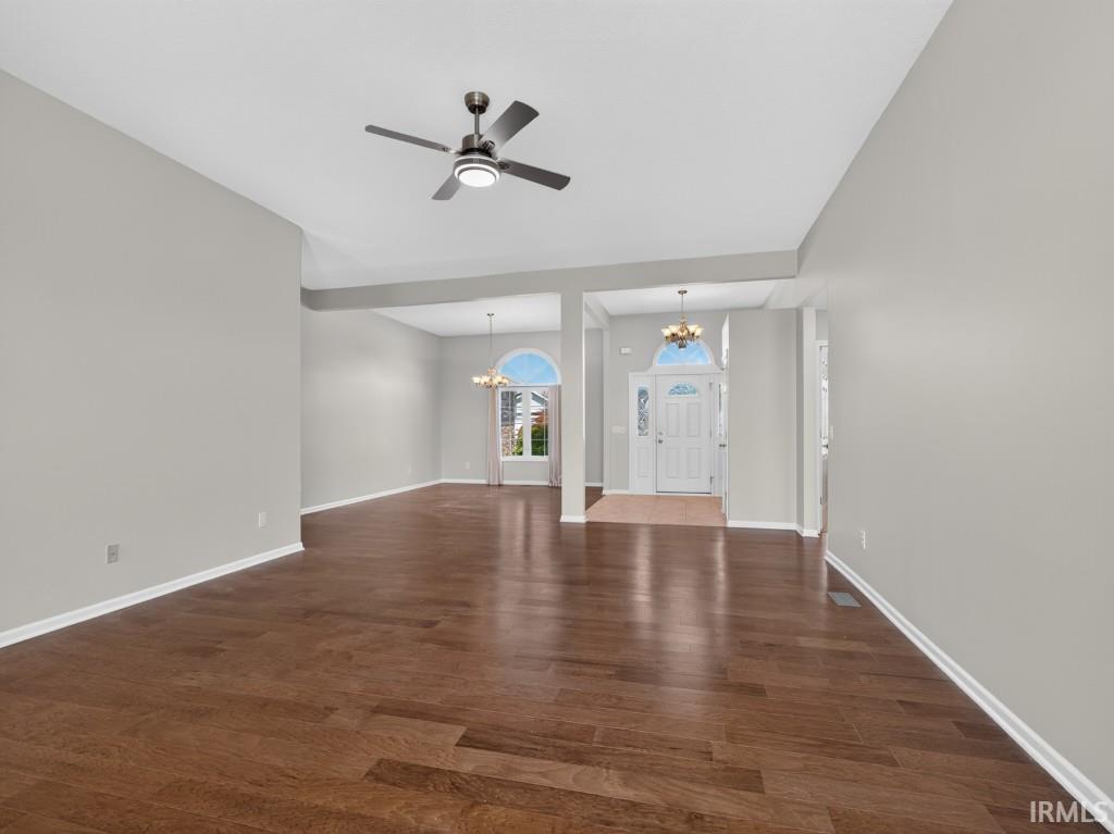 Spacious interior featuring wood-finish flooring, light gray walls, and a modern ceiling fan