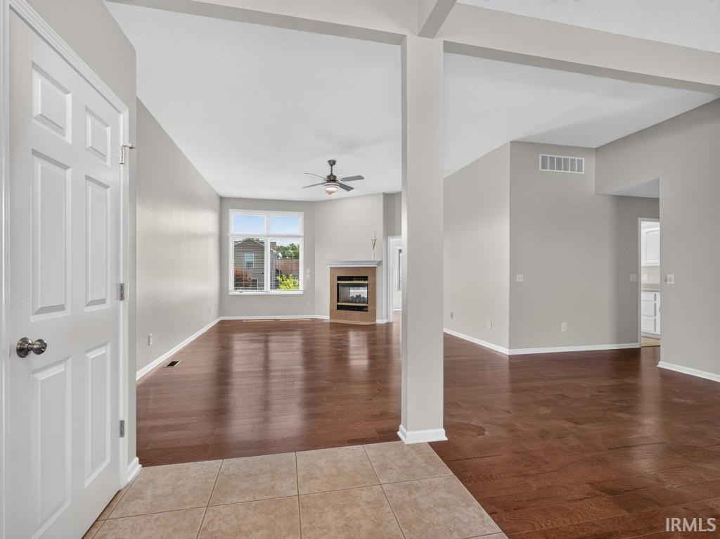 Spacious interior featuring wood-finish flooring, neutral wall tones, and a vaulted ceiling