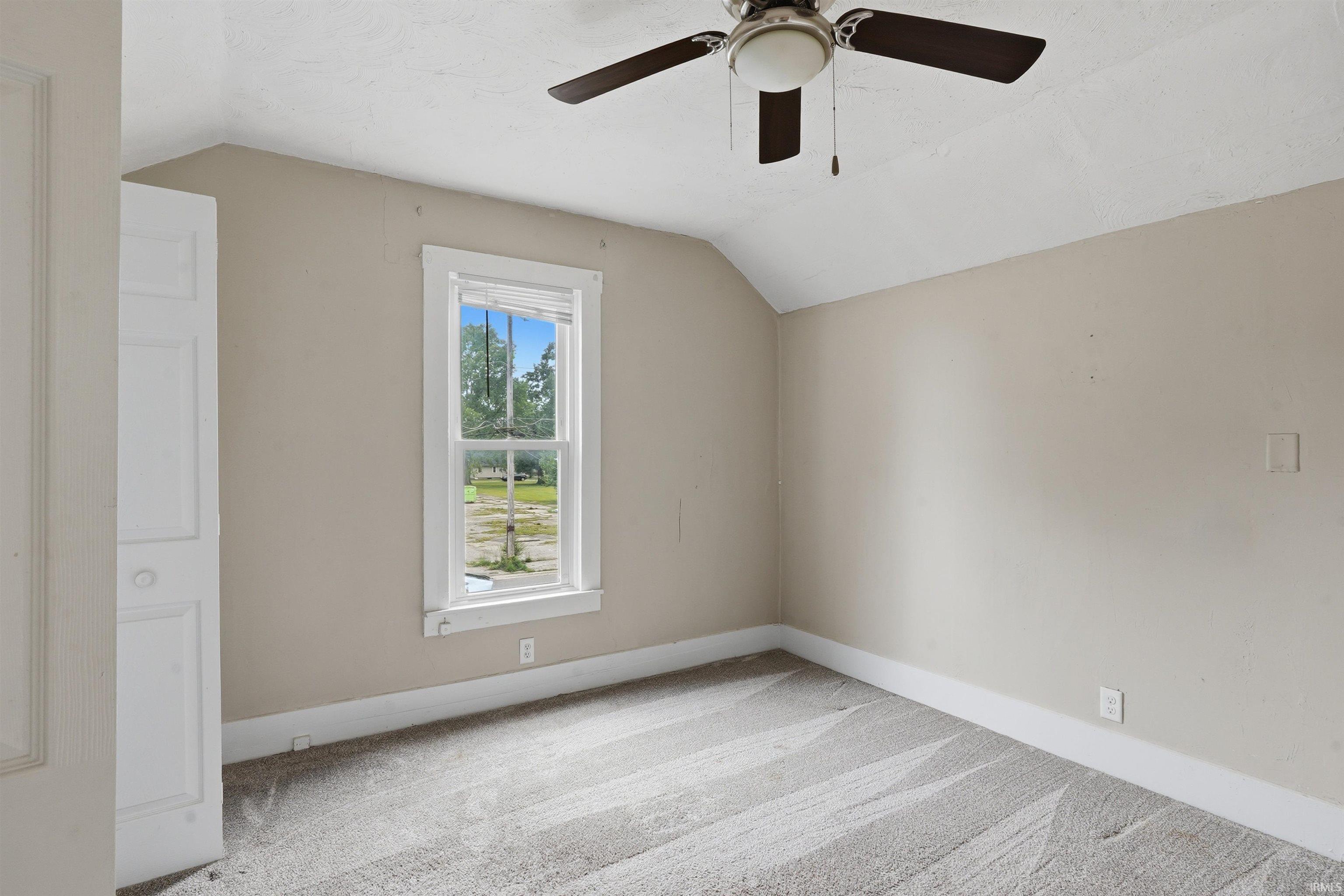 Carpeted interior room with neutral-toned walls
