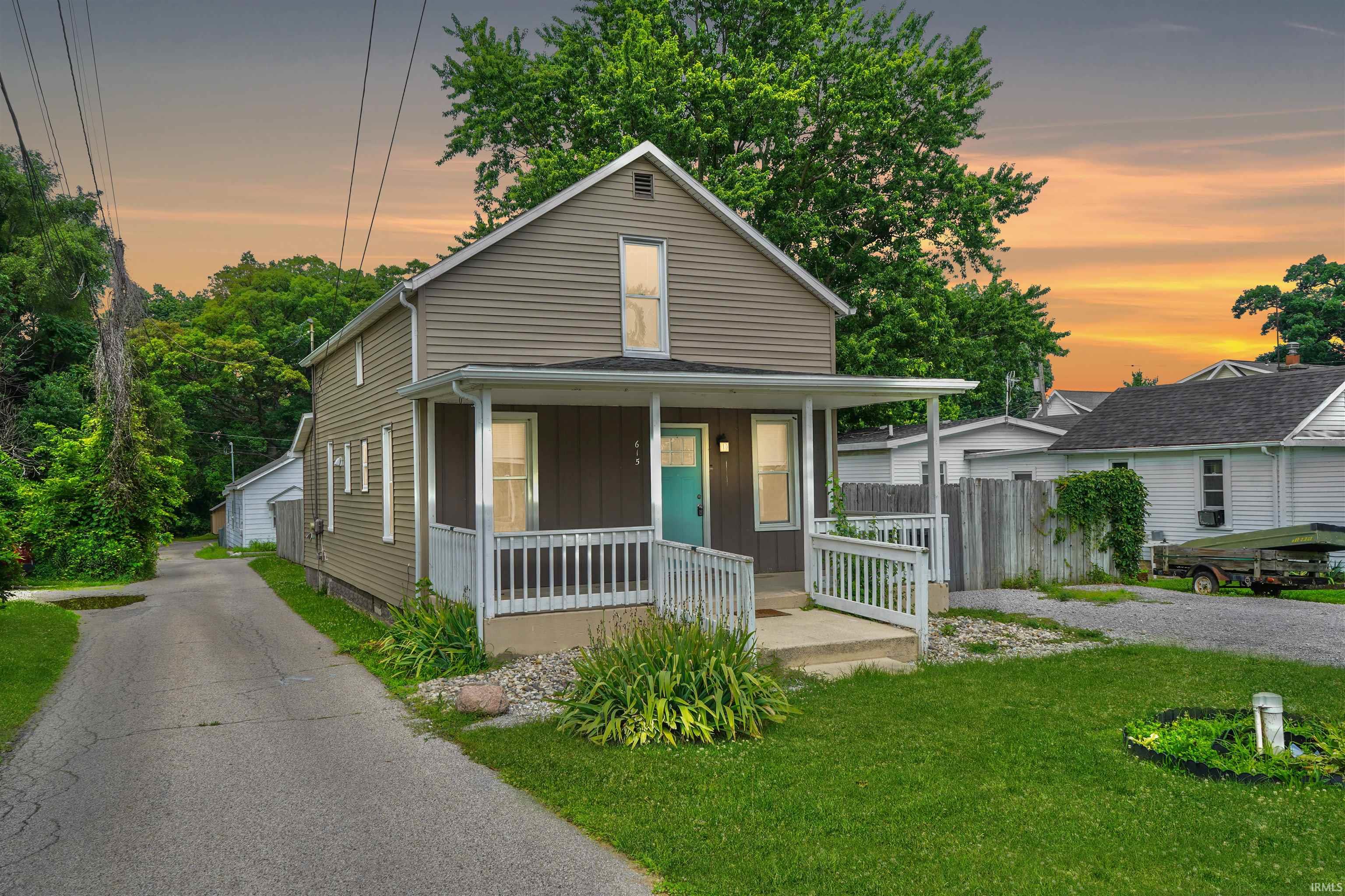 Two-story residence featuring horizontal siding and a covered front porch with white railings