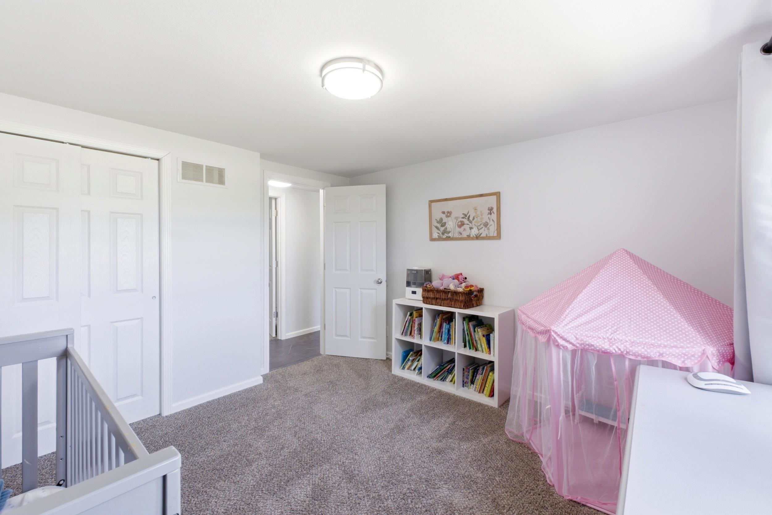 Carpeted room featuring a ceiling-mounted light fixture, white walls, and white trim