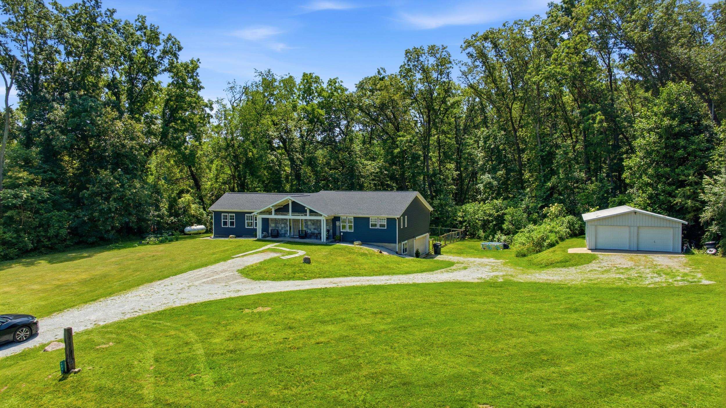 Ranch-style residence featuring a prominent gabled roofline and a gravel driveway
