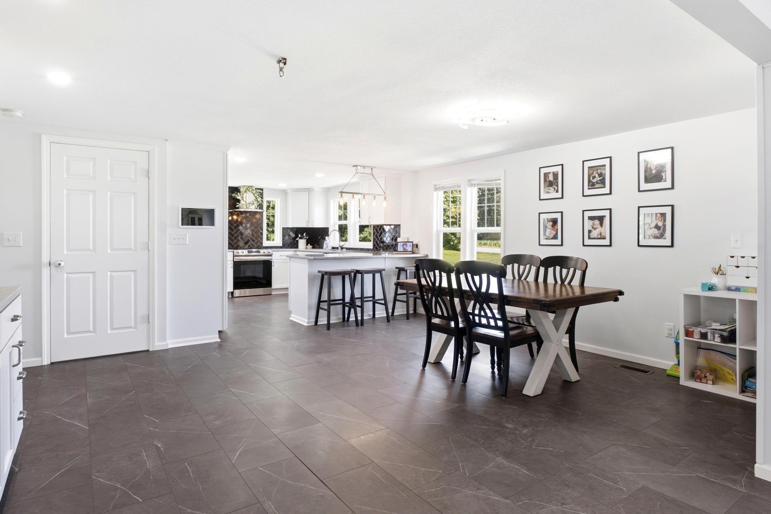 Open-concept living space featuring dark wood-finish flooring, recessed lighting, and a white interior door