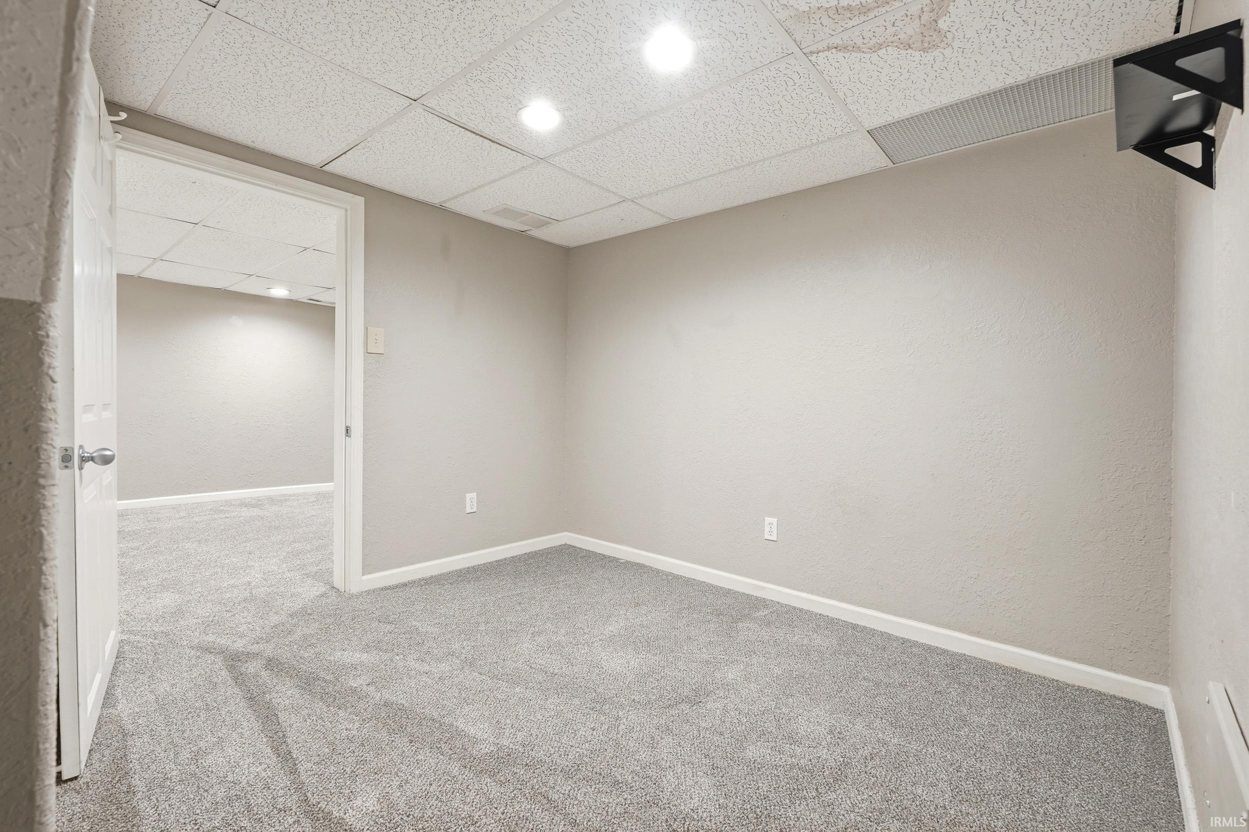 Finished interior space featuring light gray walls, white baseboards, and gray carpeting