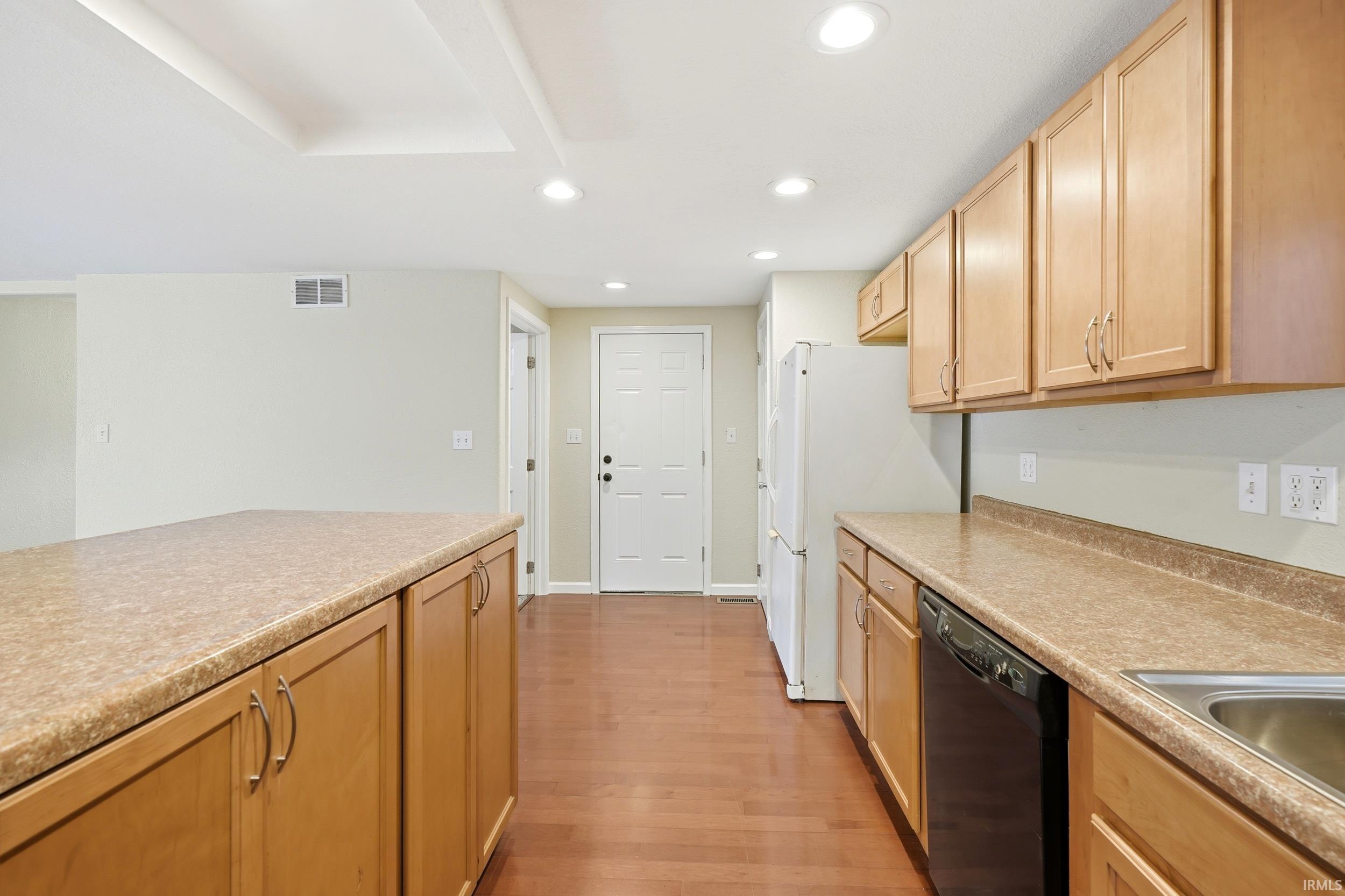 Kitchen featuring recessed lighting, natural wood-finish cabinetry, light brown countertops, hardwood flooring, and a stainless steel sink