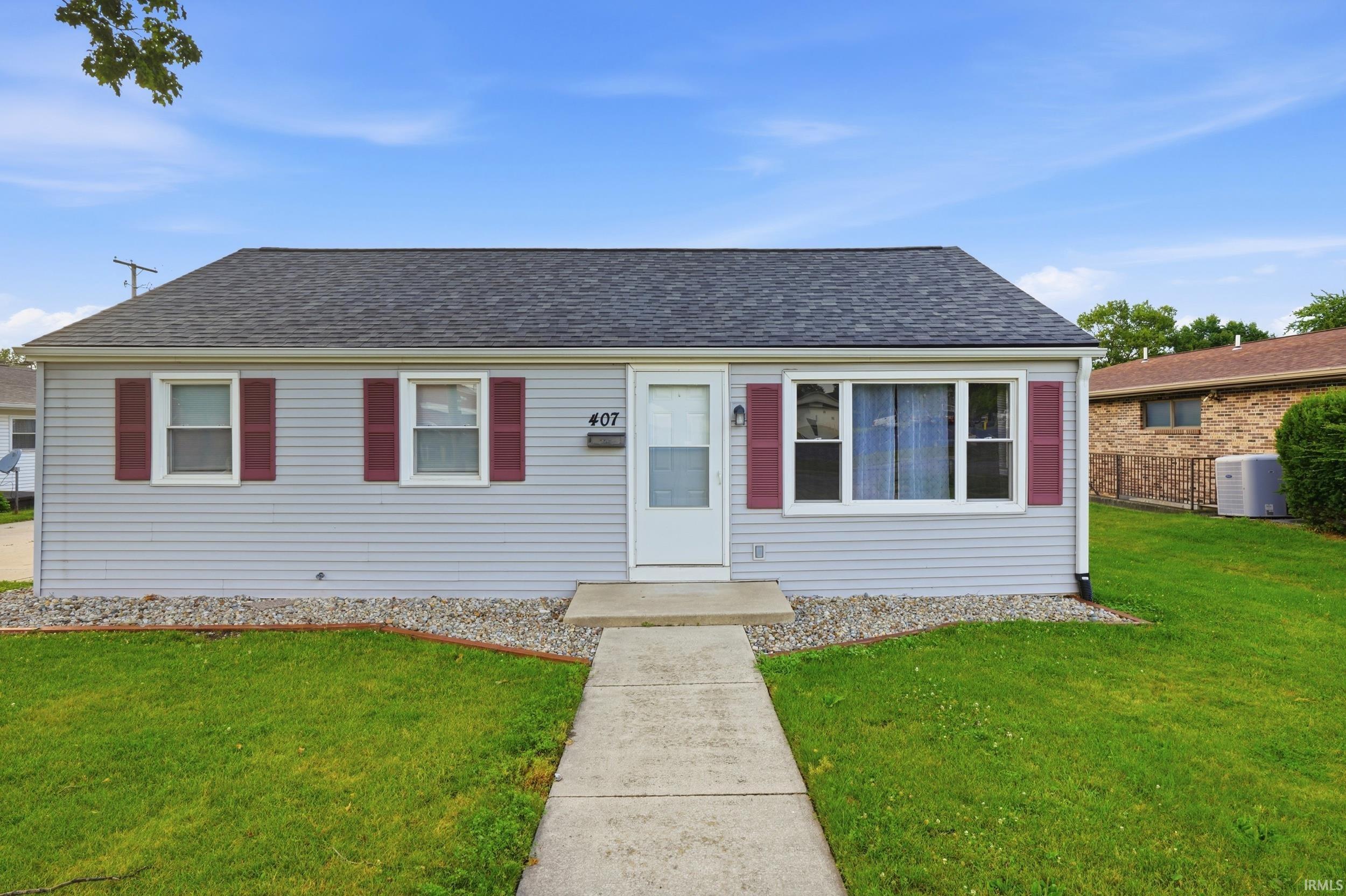 Ranch-style exterior featuring light gray horizontal siding and a dark shingle roof