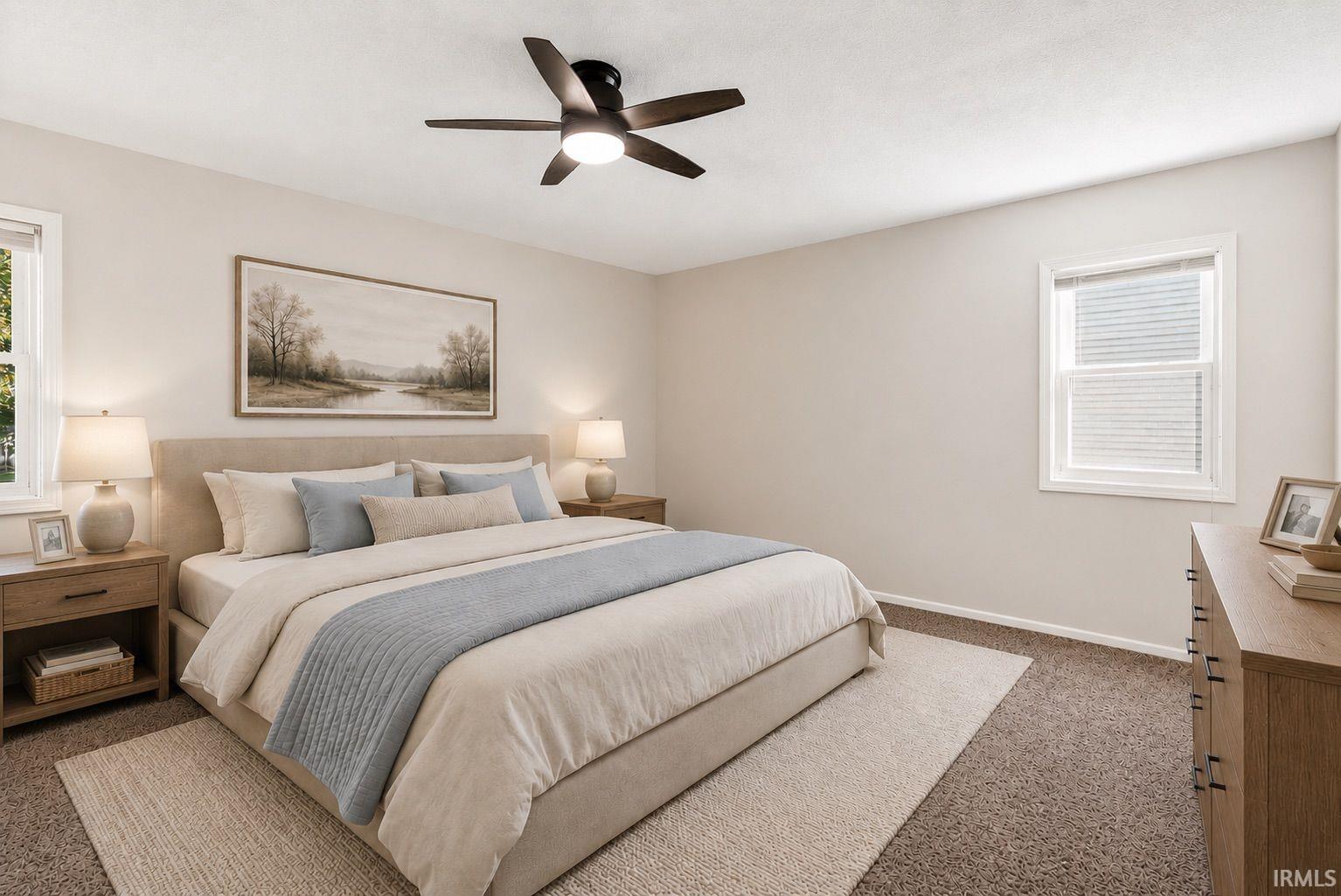 Carpeted bedroom featuring a ceiling fan with integrated lighting, two windows with white trim, and light neutral wall paint