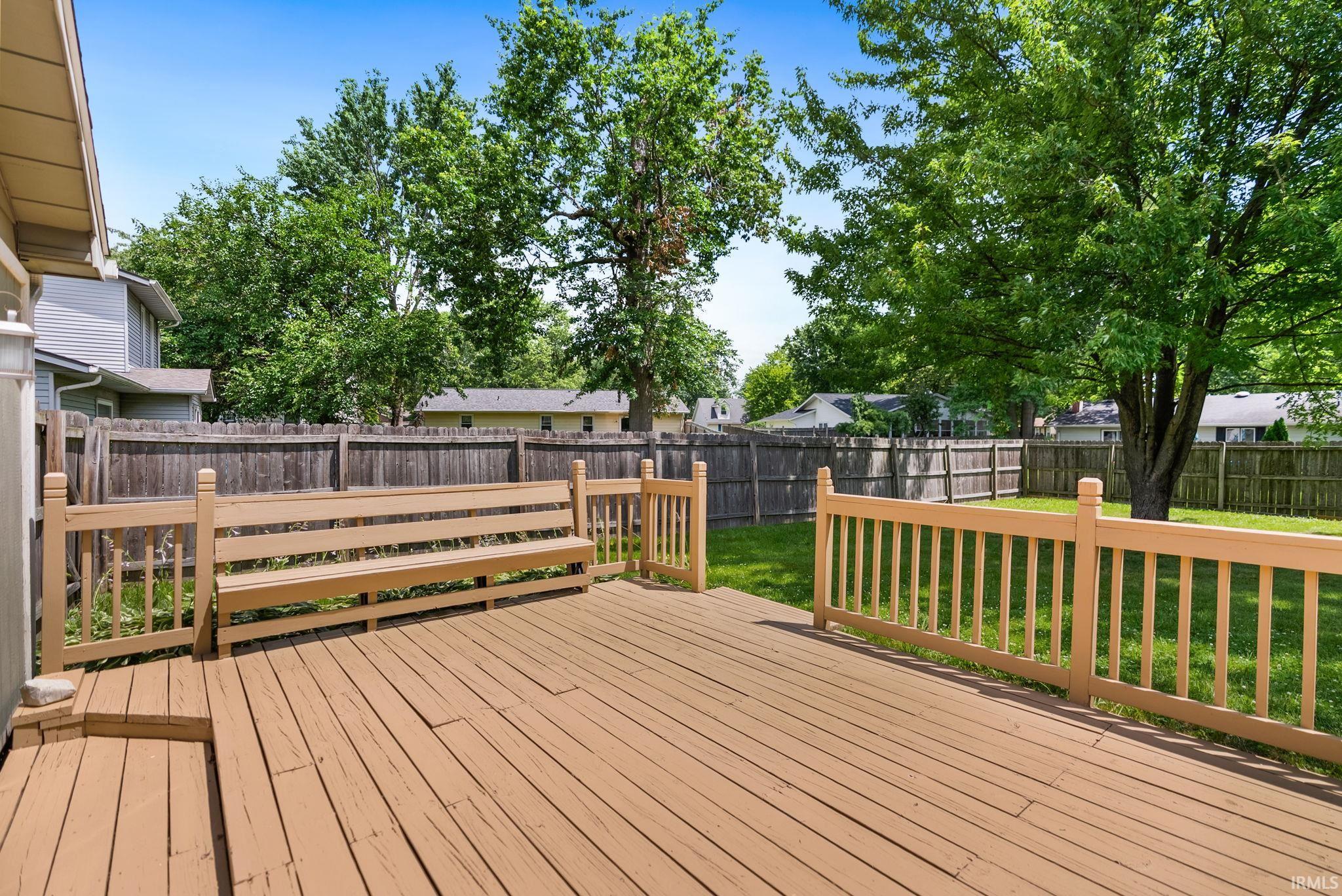 Spacious outdoor deck featuring wood-finish decking and integrated wooden railing