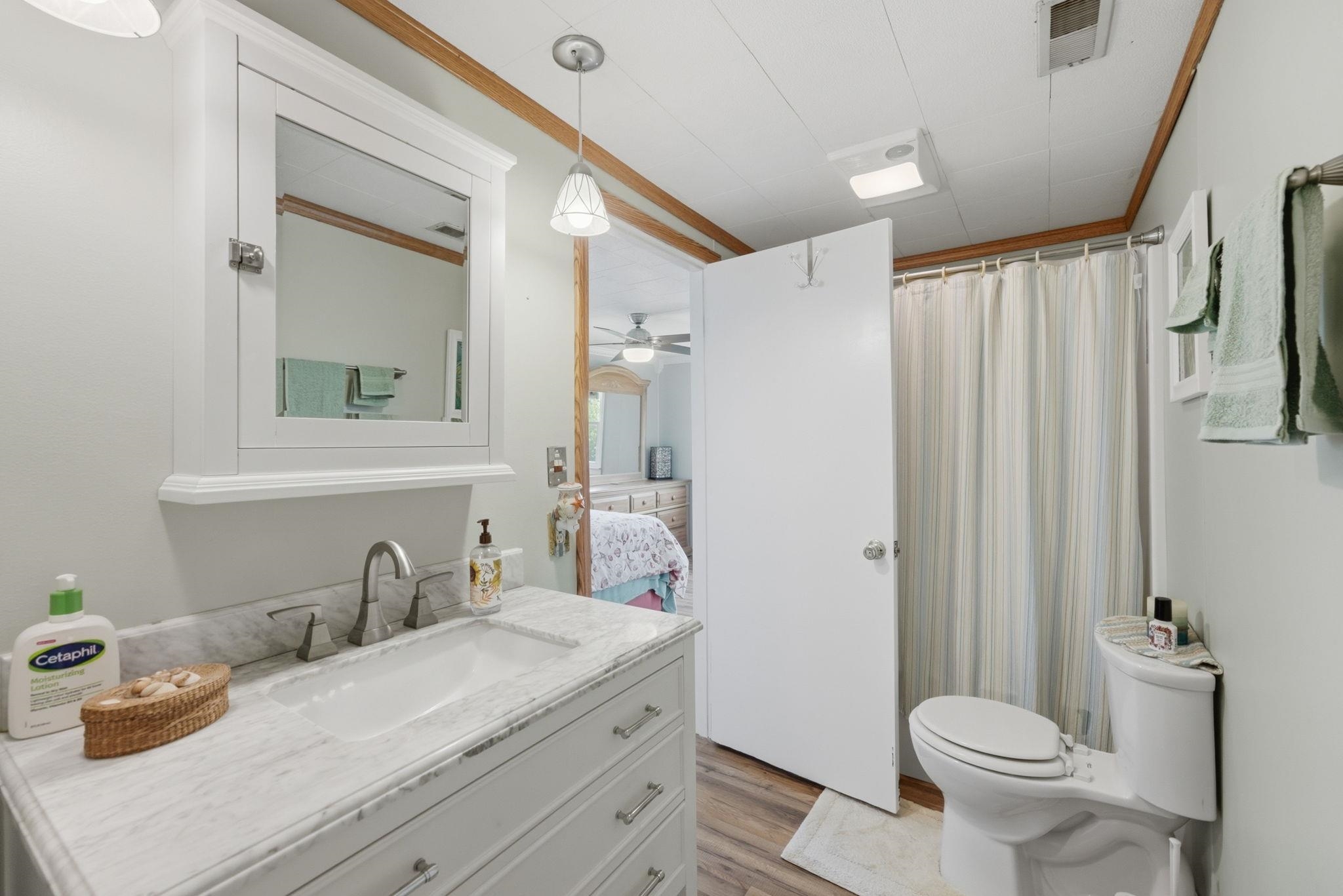 Jack -n- Jill FULL Bathroom featuring a white vanity with a rectangular undermount sink, a gray-veined countertop, brushed nickel faucet, and matching cabinet hardware