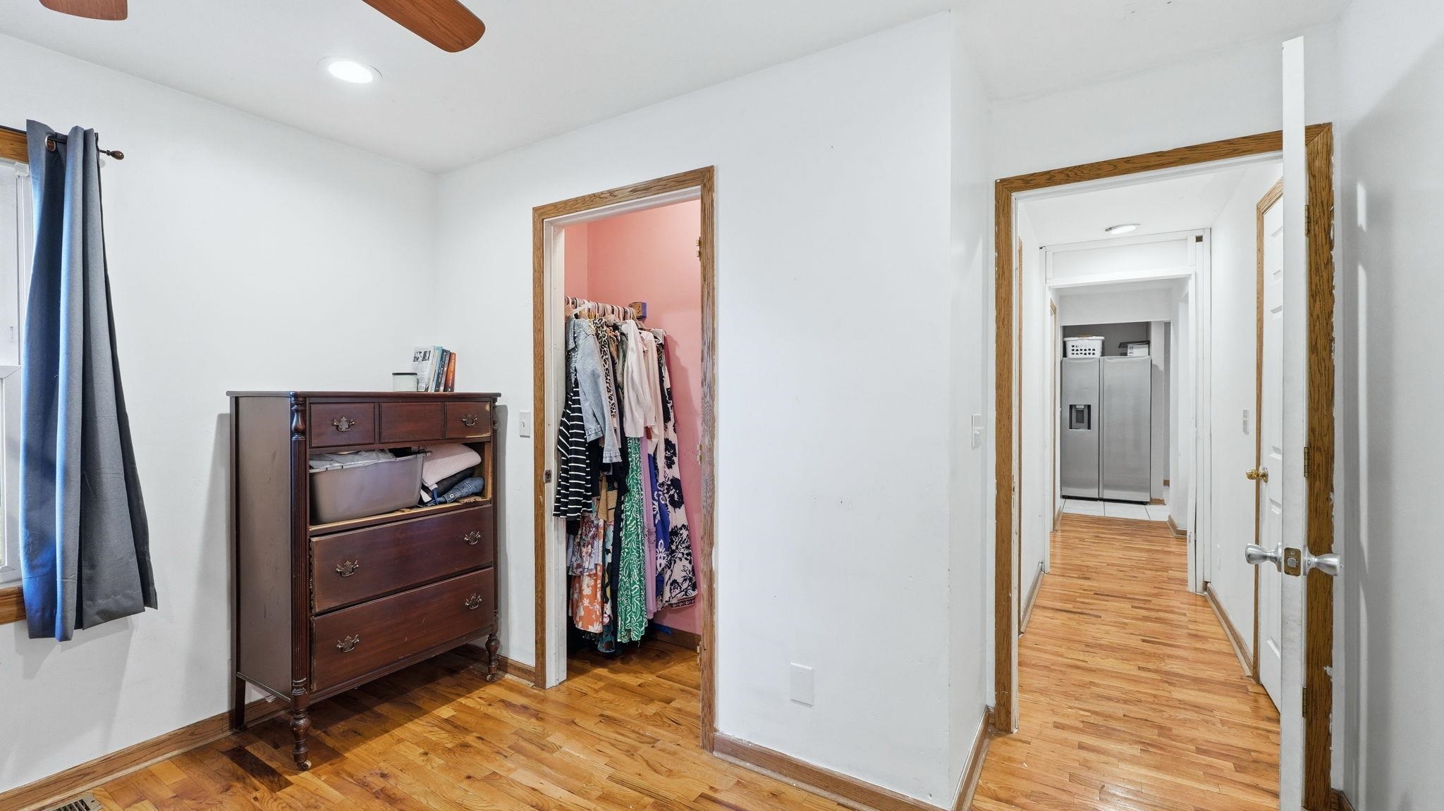 Bedroom featuring wood-finish flooring, a ceiling fan, and white walls
