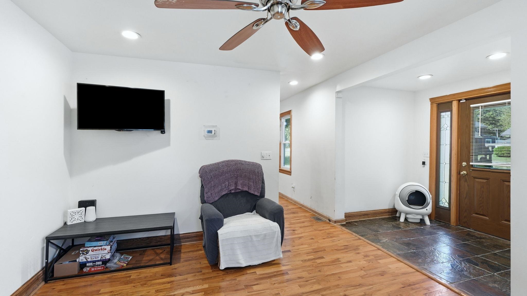 Entryway featuring dark slate flooring, a wood-finish door with sidelight, and wood trim