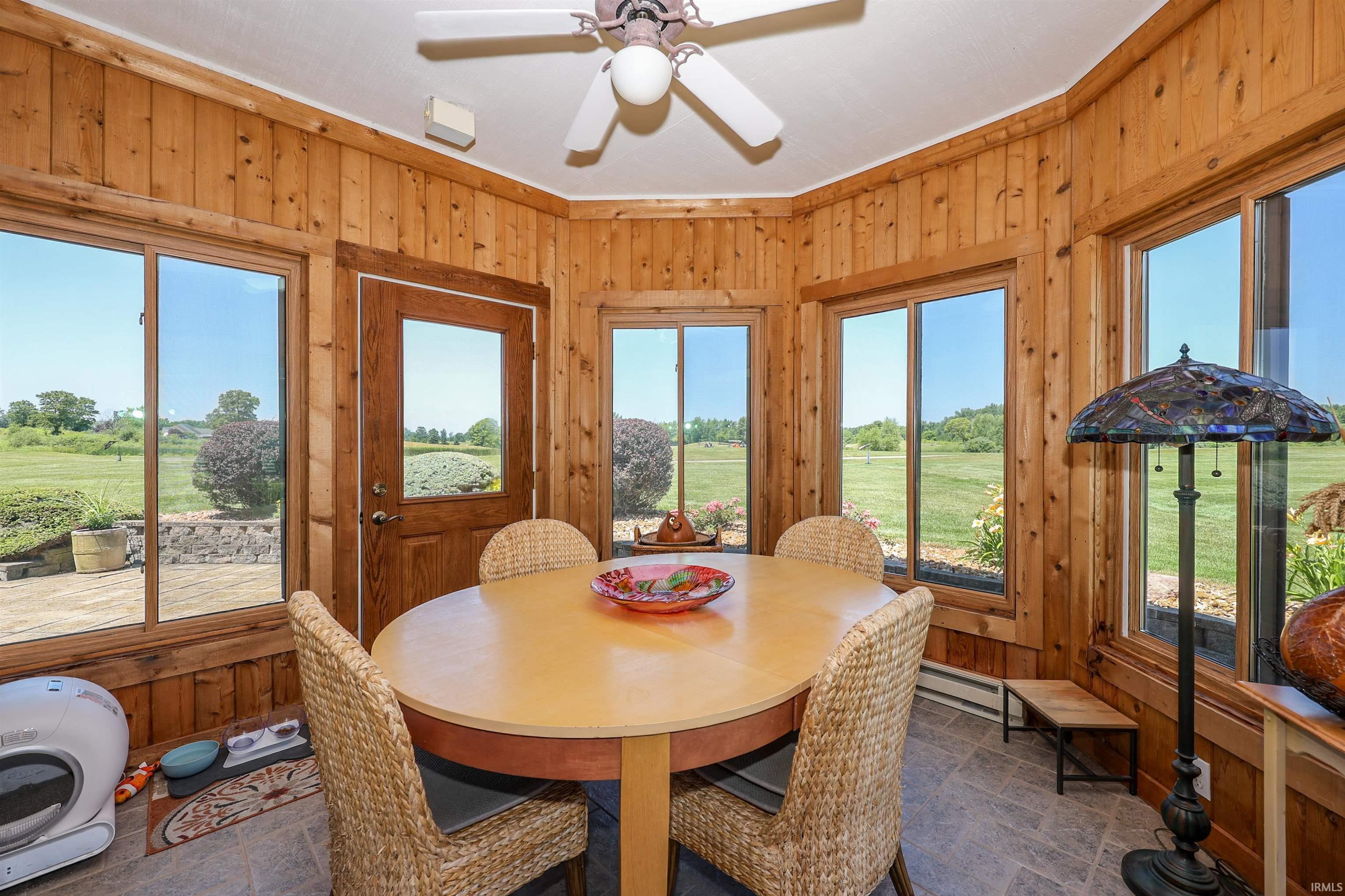 Sun-filled room featuring extensive wood paneling and multiple windows