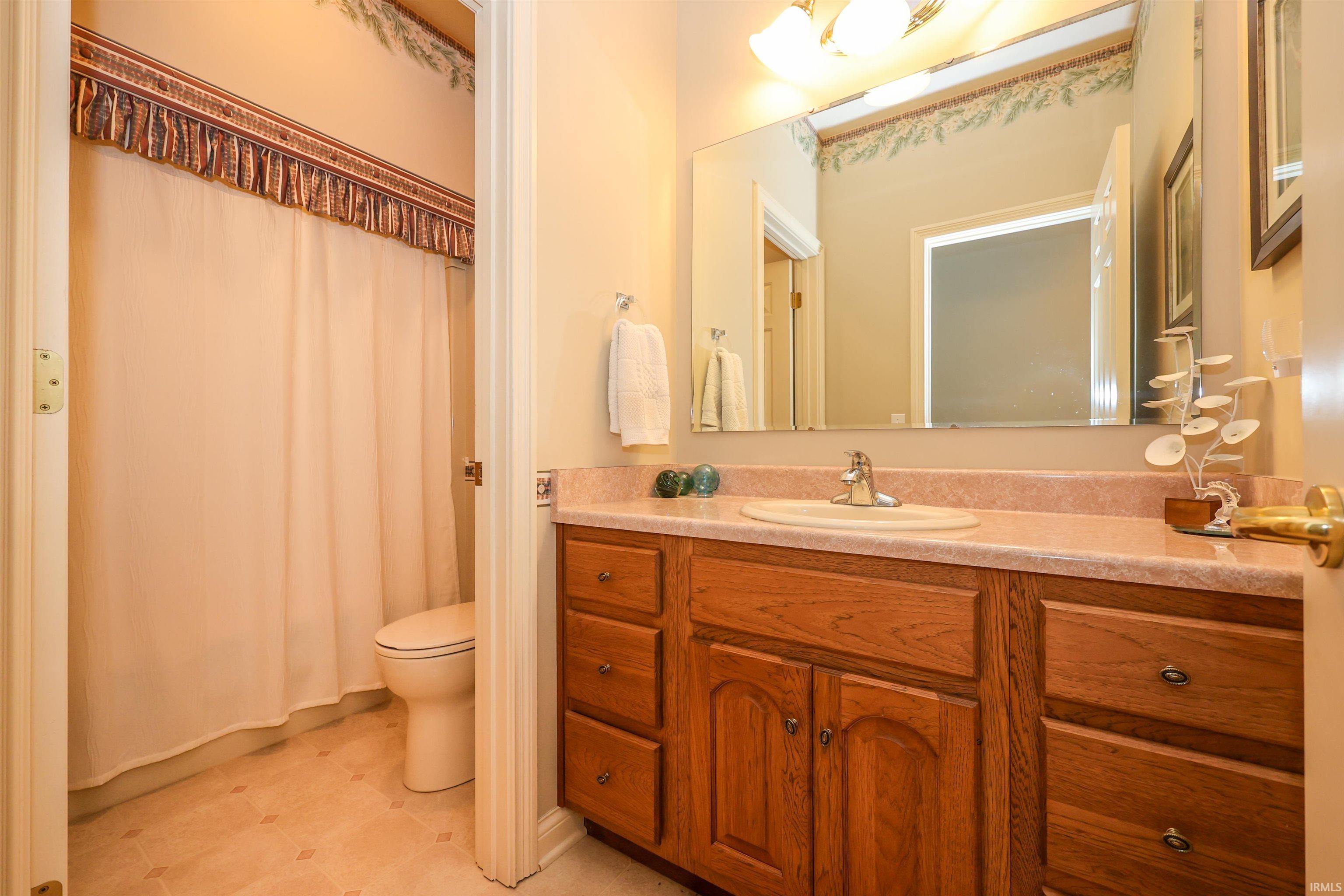 Bathroom vanity featuring a wood-finish cabinet with multiple drawers and a double-door storage compartment