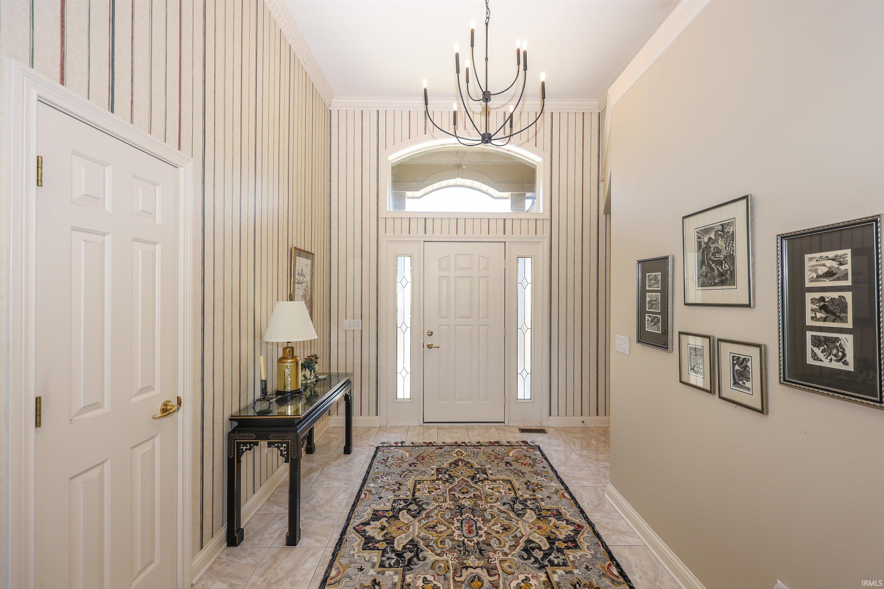 Grand entryway featuring a paneled door with glass sidelights and an arched transom window