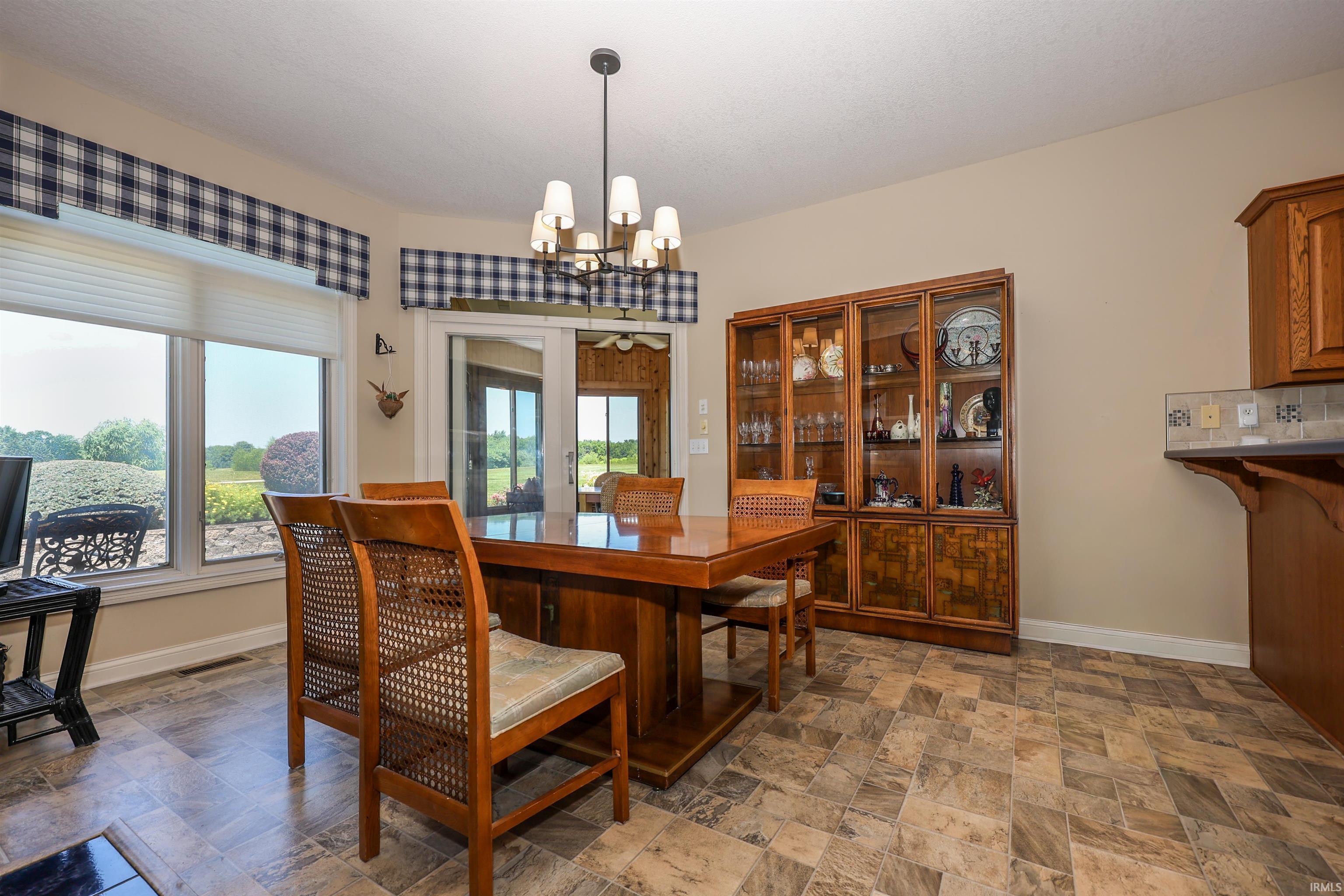 Dining area featuring wood-finish flooring and a contemporary chandelier