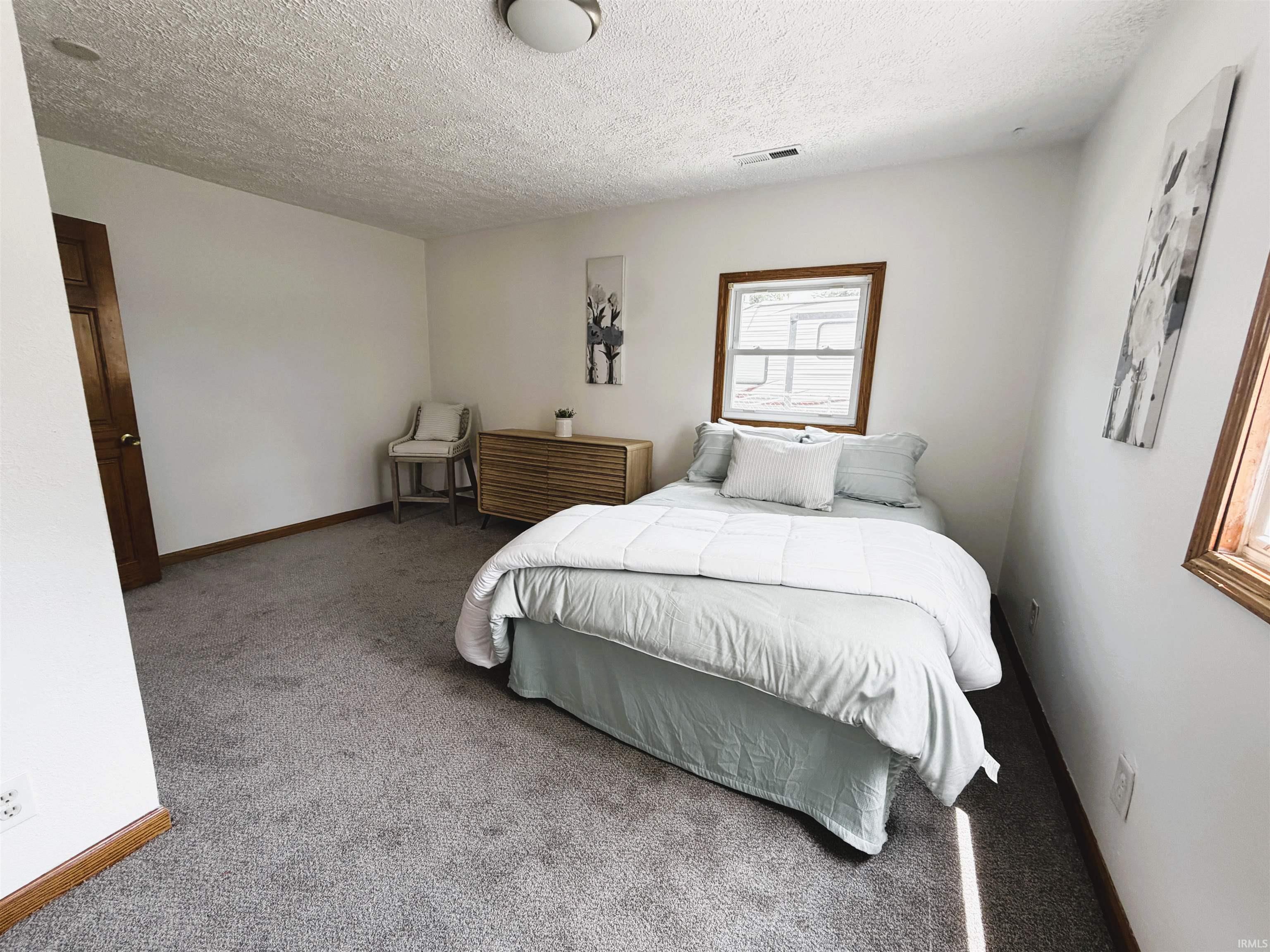 Bedroom featuring neutral gray carpeting and white painted walls